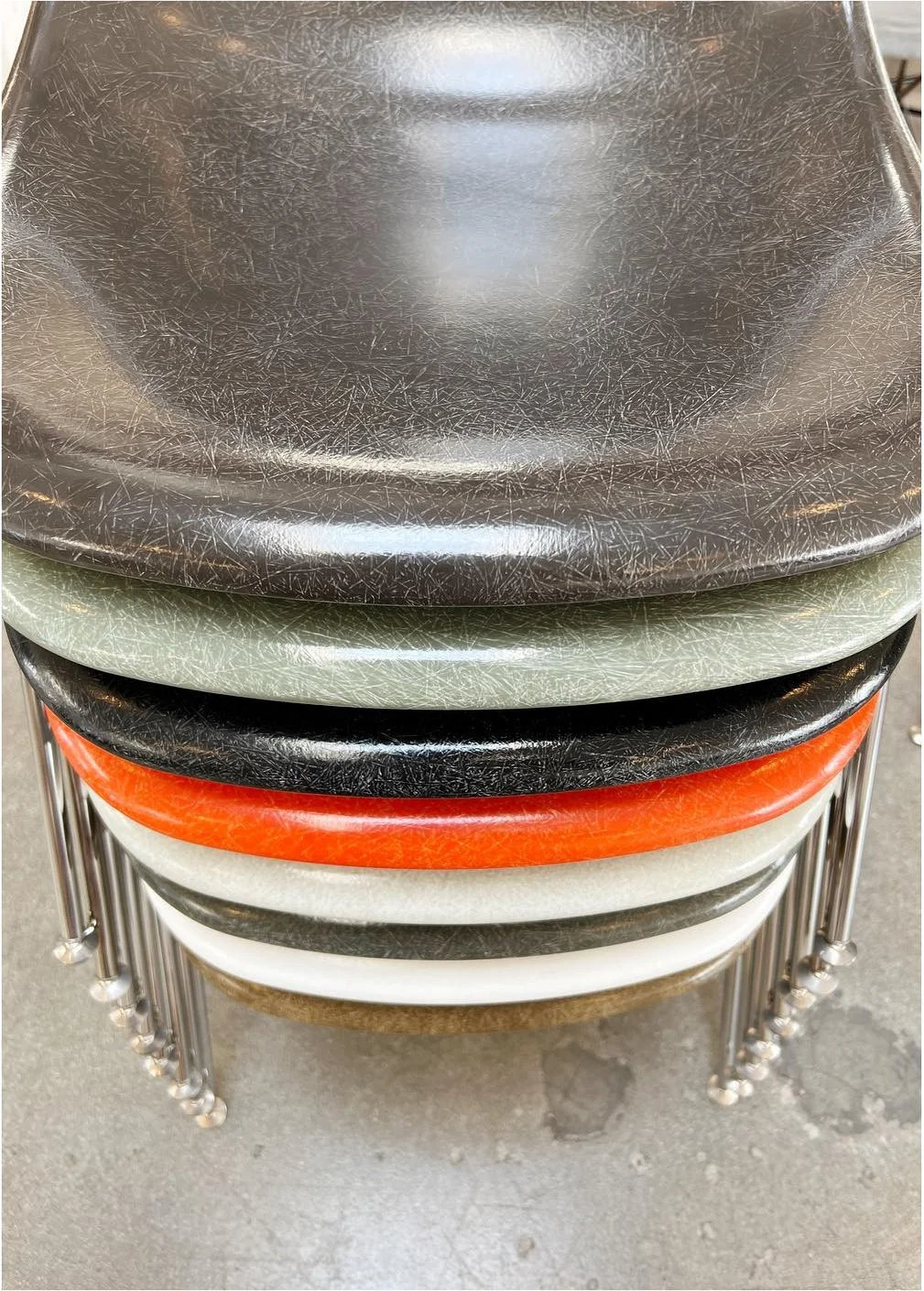 Close view of stacked dark and brightly colored fiberglass chair shells