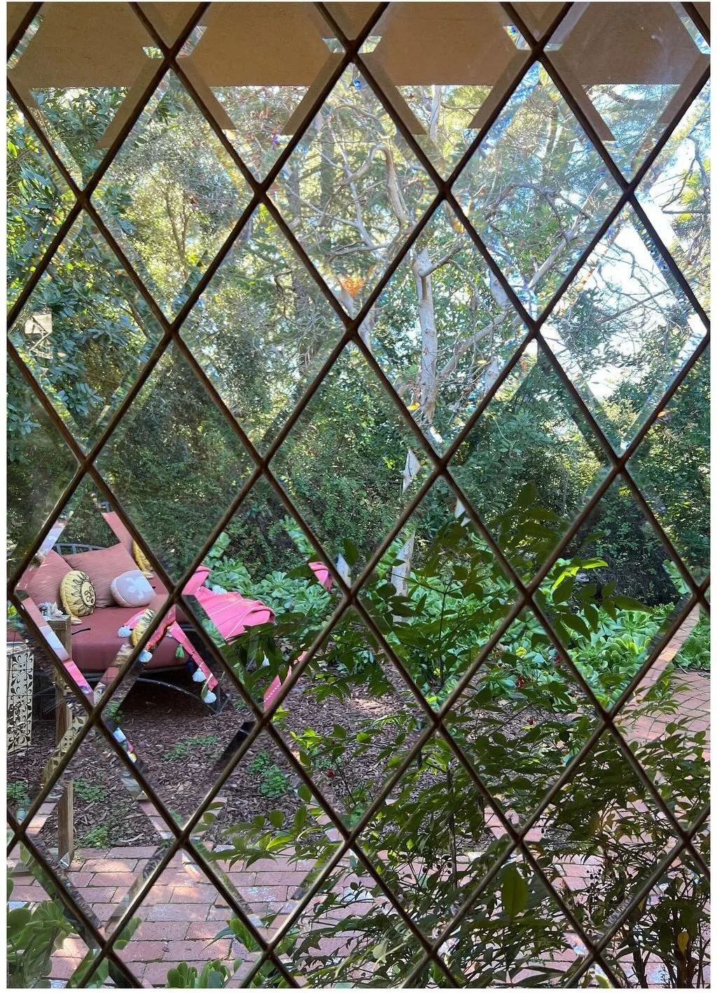 Garden viewed through a diamond-patterned leaded glass window