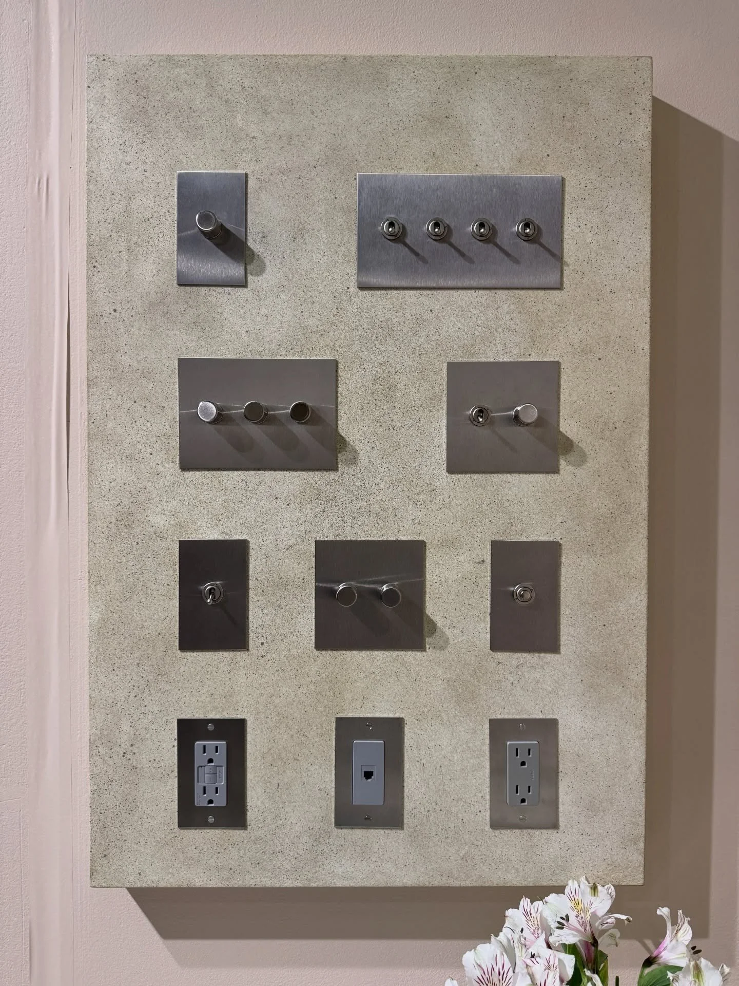 Metal plumbing control samples arranged on a stone display