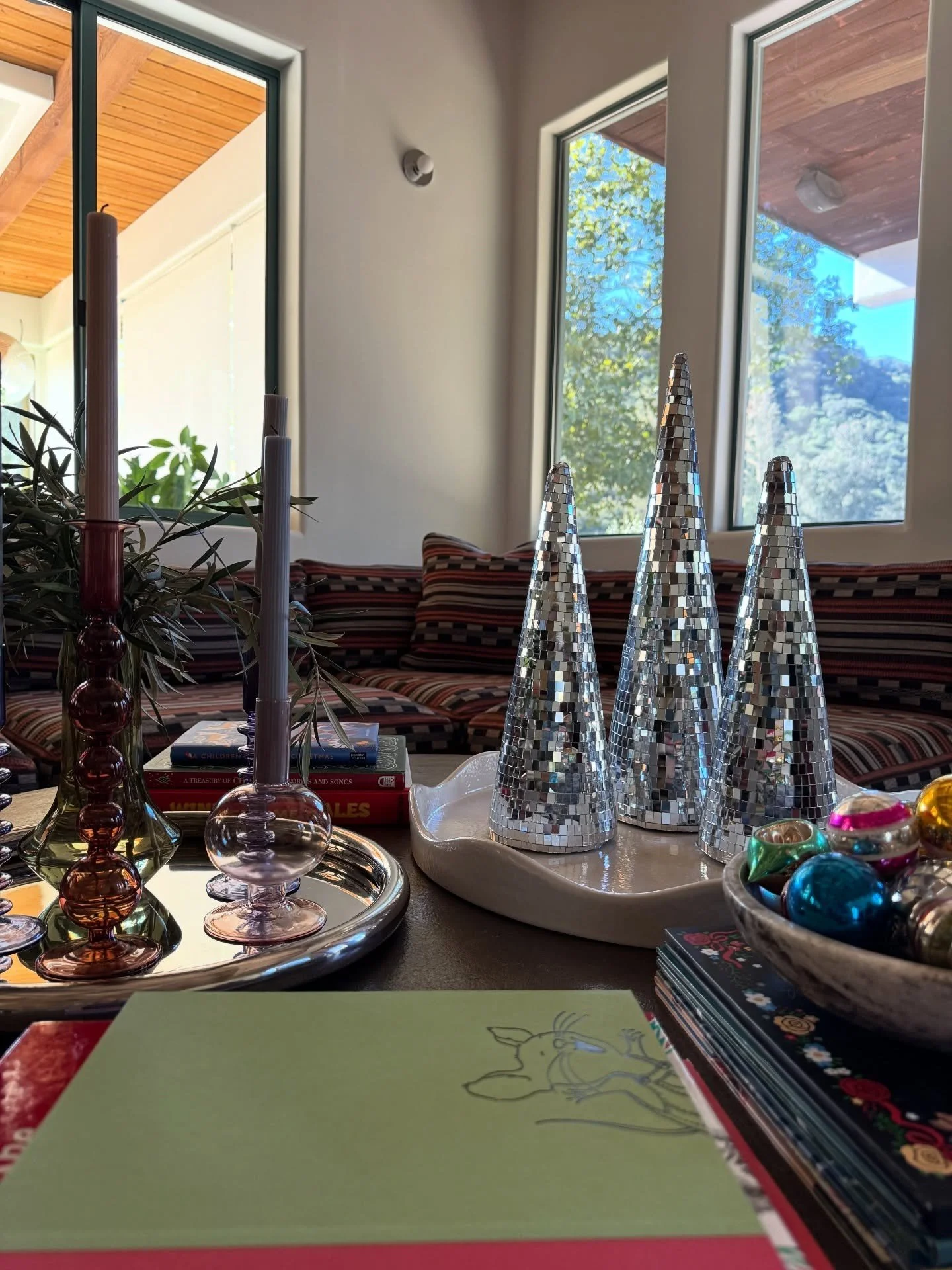 Coffee table with silver tree ornaments candles and stacked books
