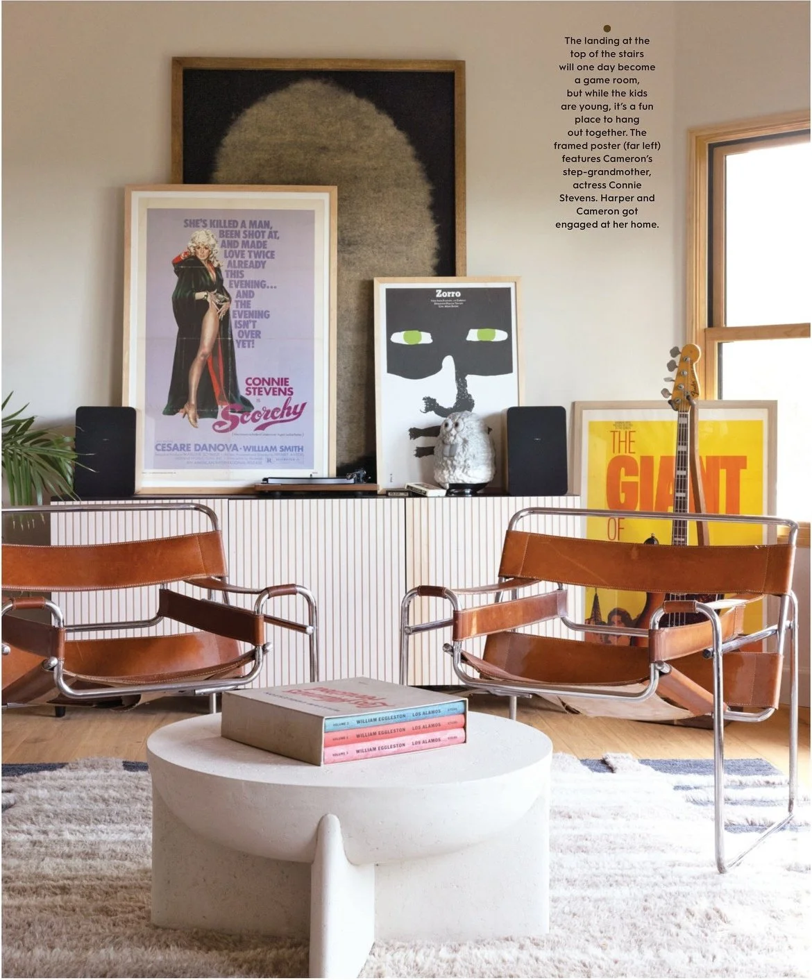Editorial sitting room with wood chairs and layered framed art