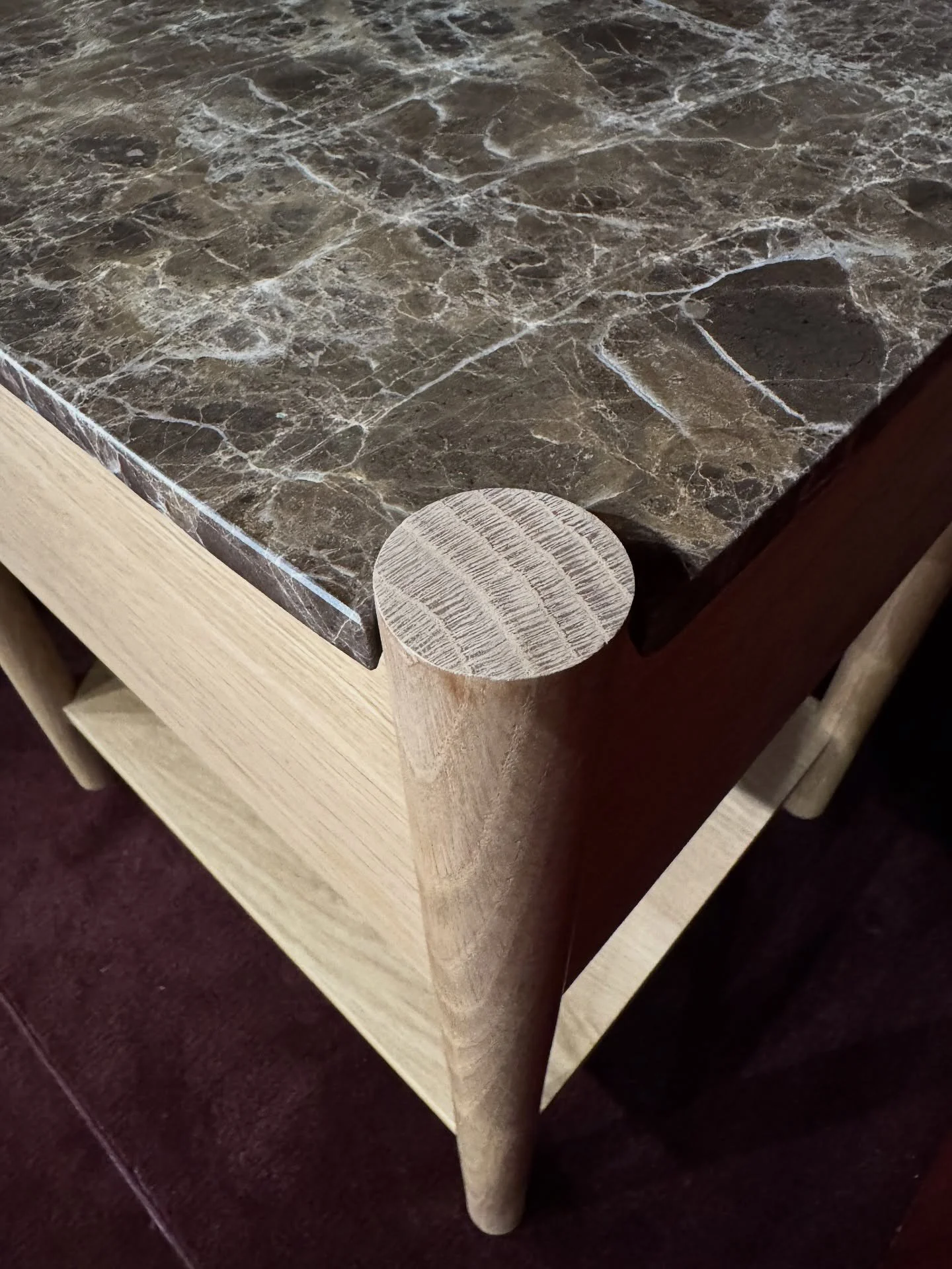 Dark veined stone coffee table with cylindrical wood corner detail