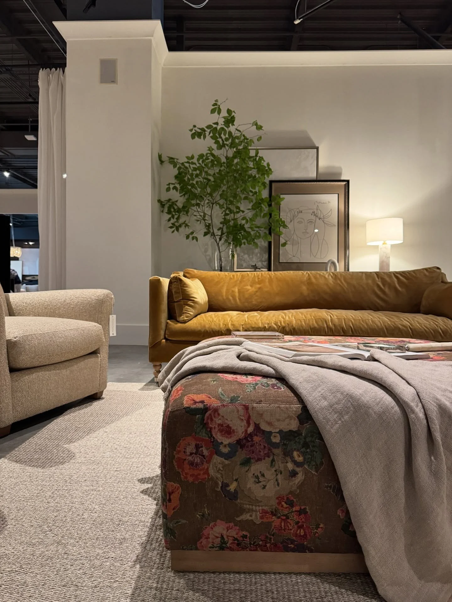 Mustard sofa beside a bed with a floral upholstered bench