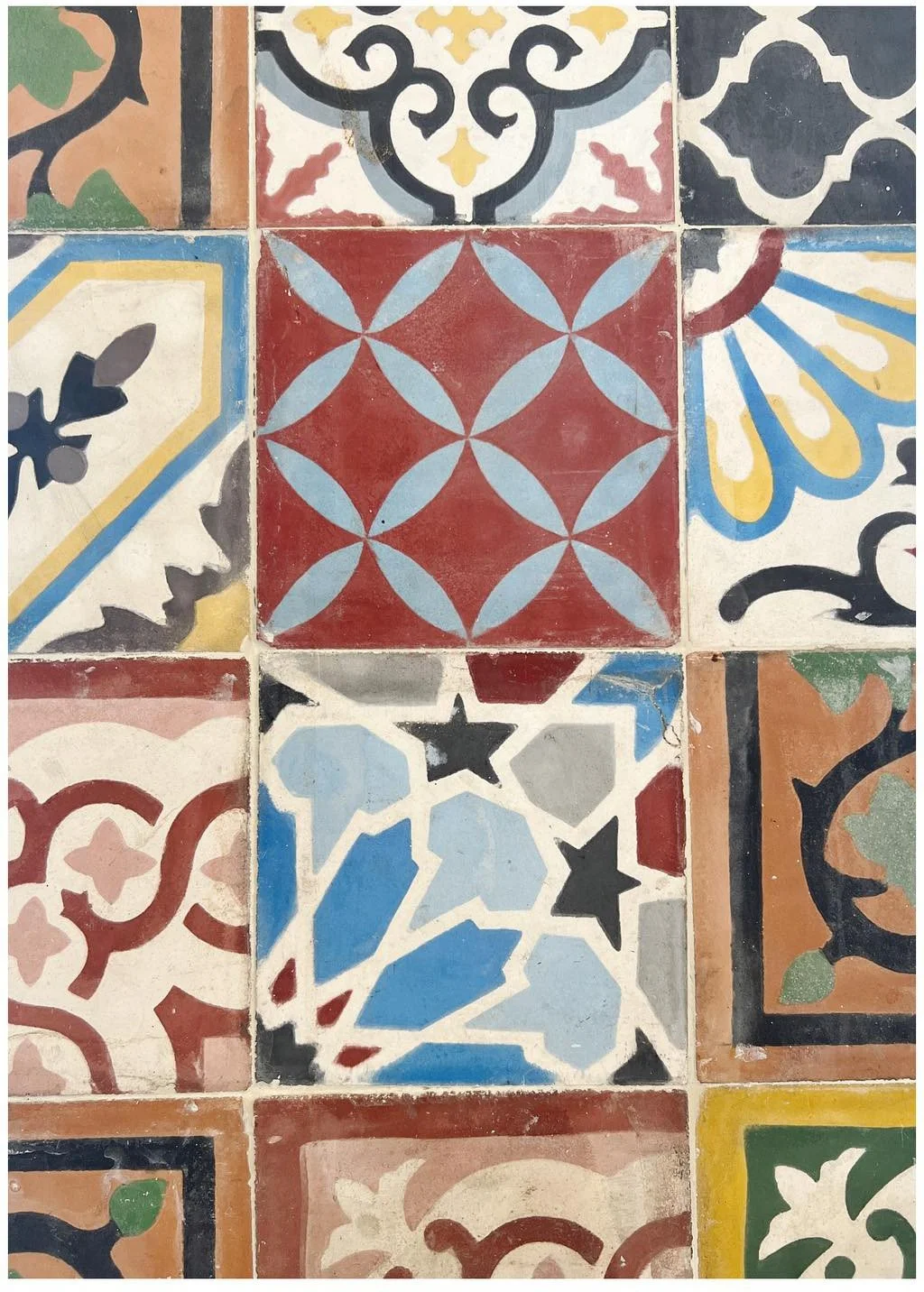 Patchwork of colorful patterned floor tiles with geometric and floral motifs