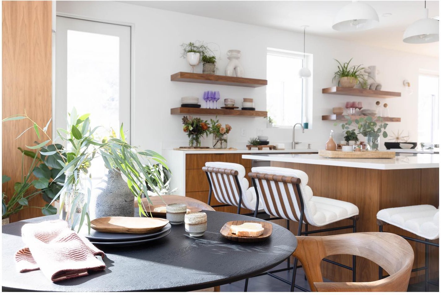 Kitchen island styled with plates flowers and folded table linens