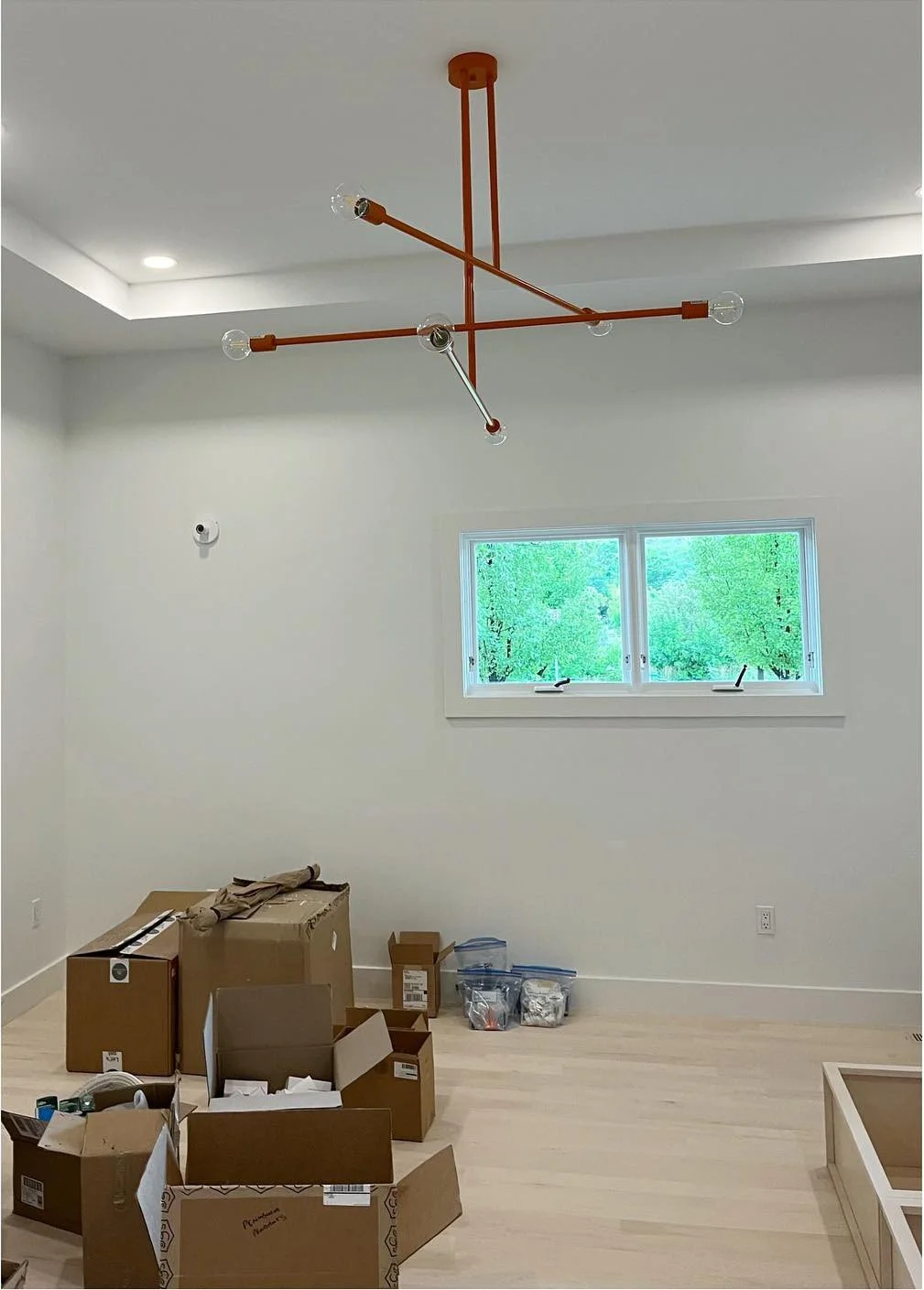Orange branching ceiling fixture in a freshly painted renovation room