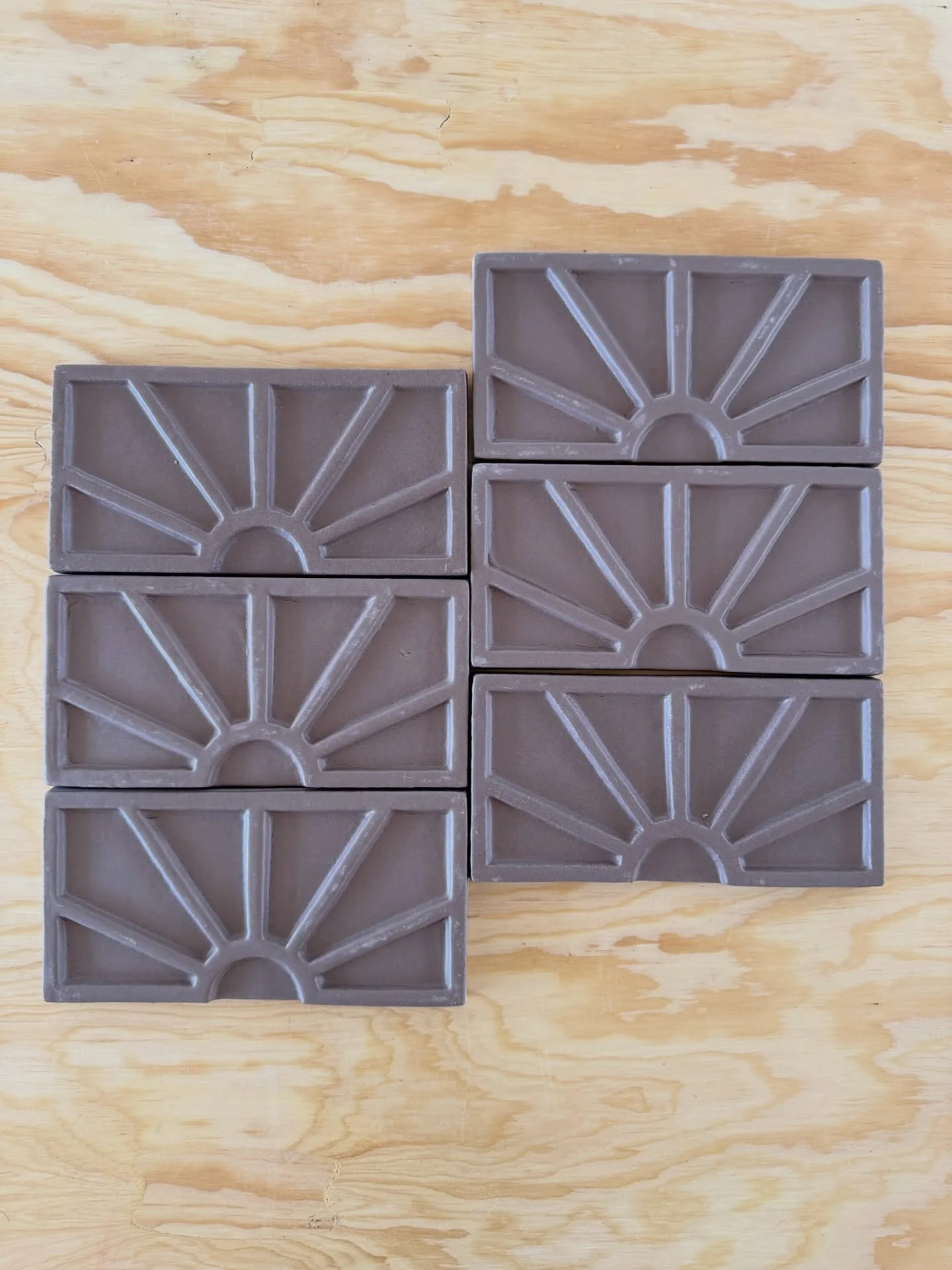 Purple geometric relief tile samples on a wood board