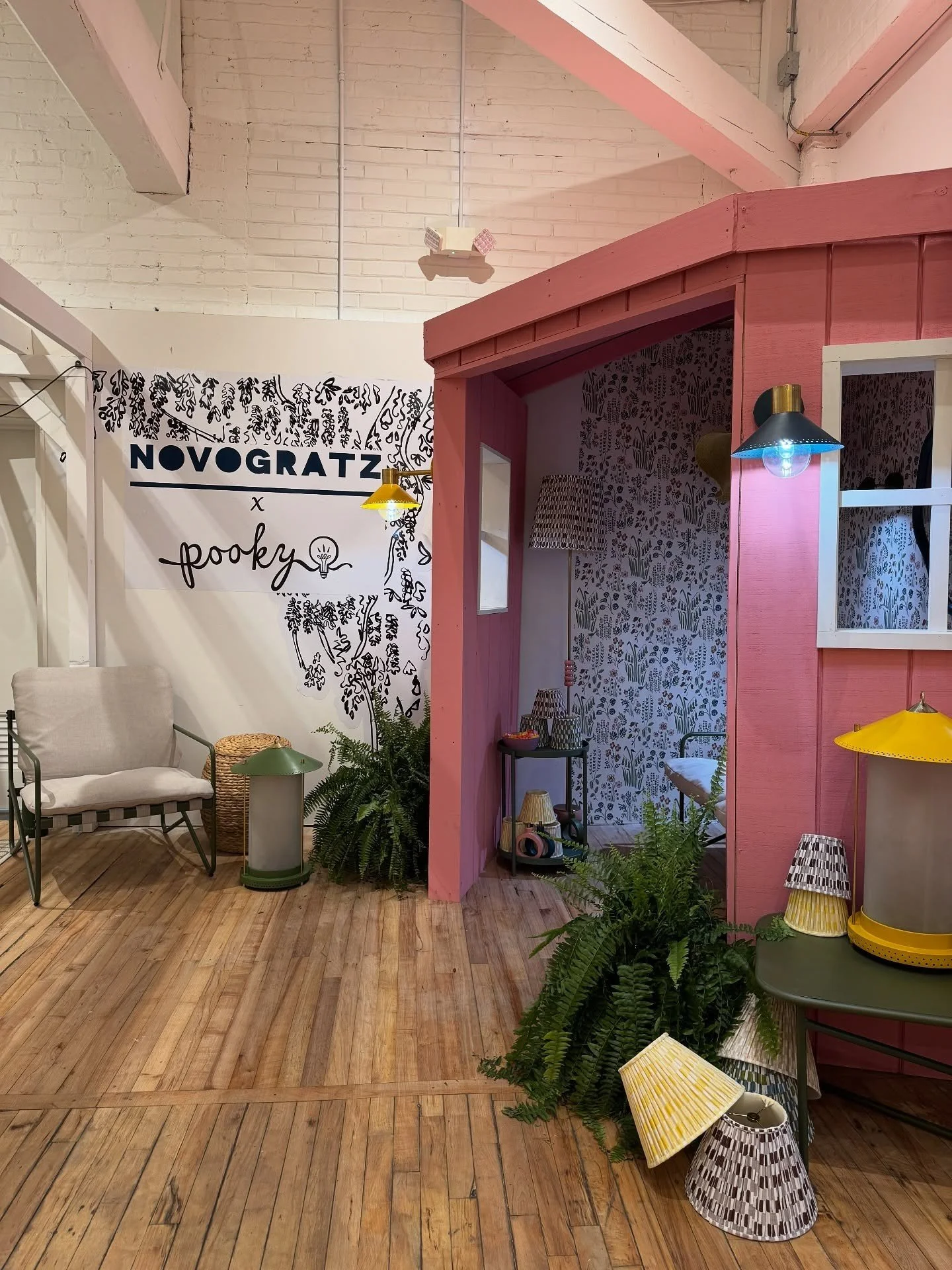 Pink display cabinet and floral wallpaper in a design showroom