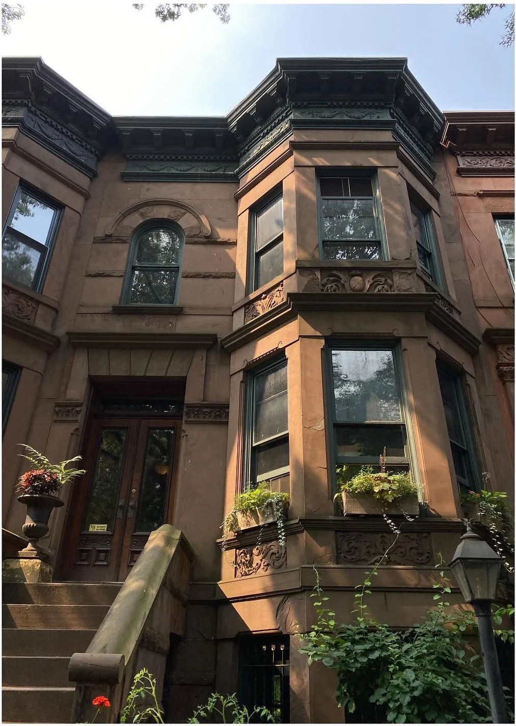 Bay-fronted brownstone facade with carved stone detailing