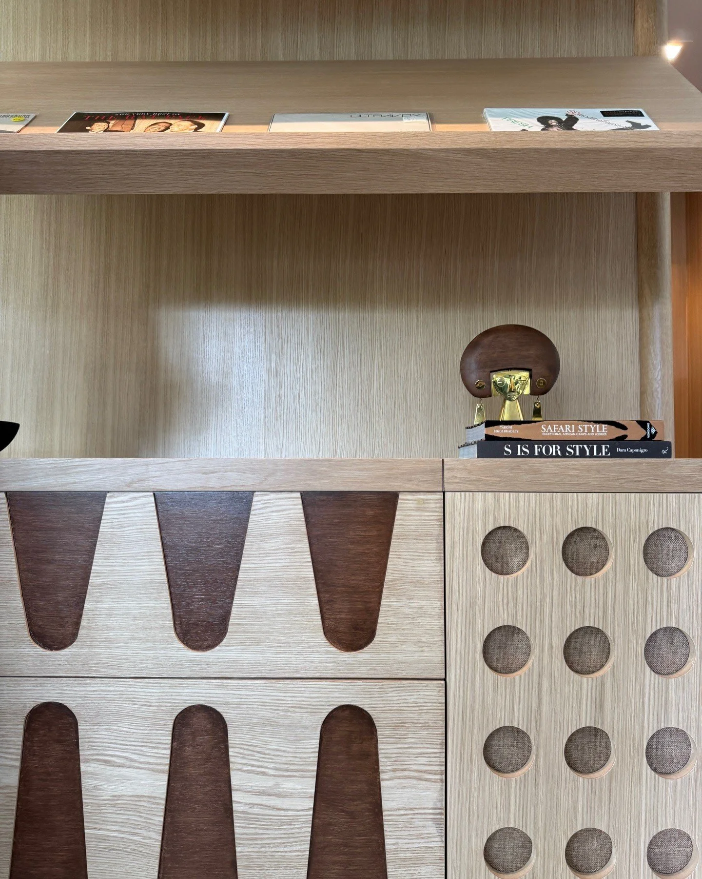 Wood built-in shelving with circular and tapered carved details