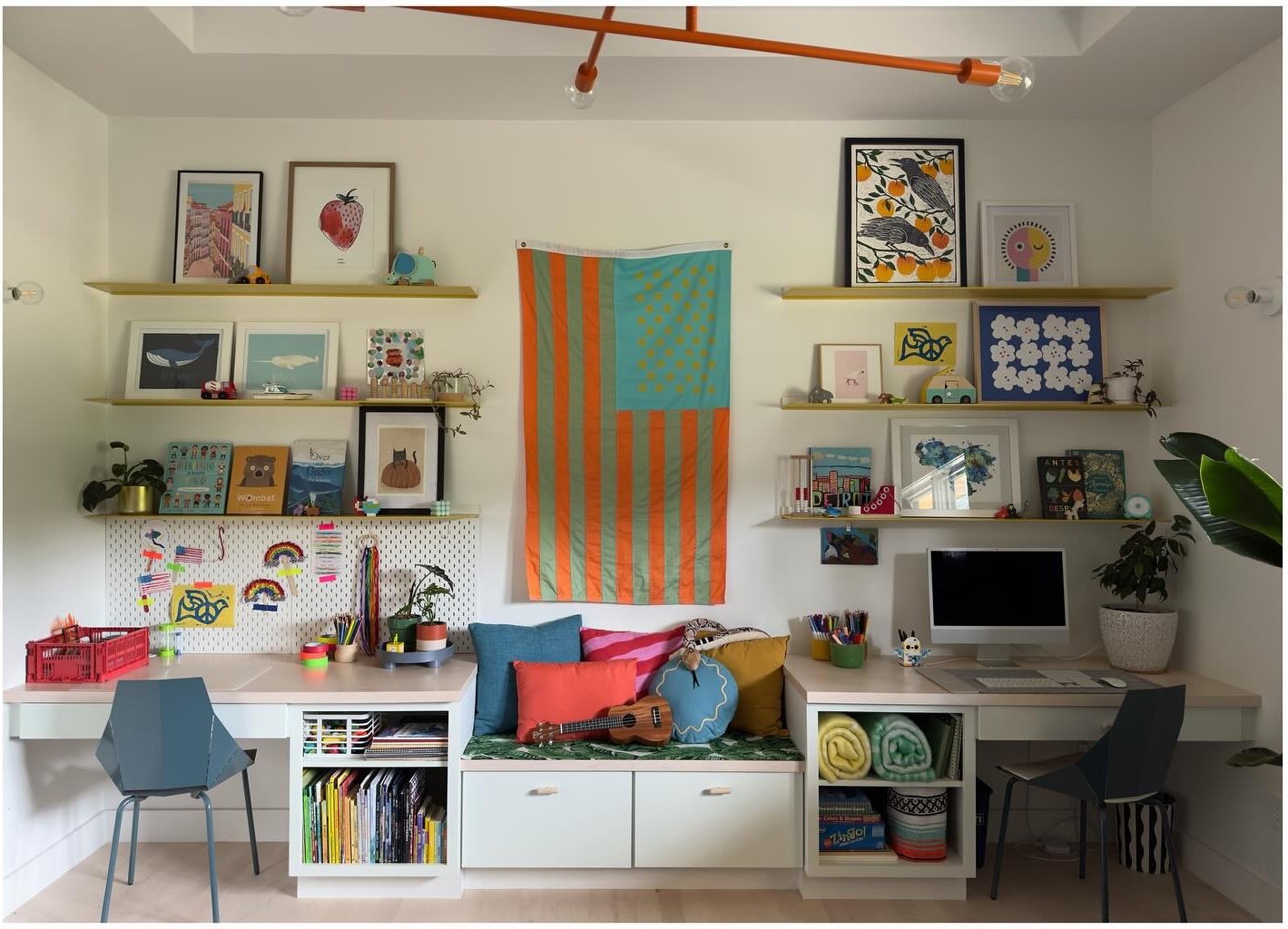 Playroom art wall with shelving desks and colorful cushions