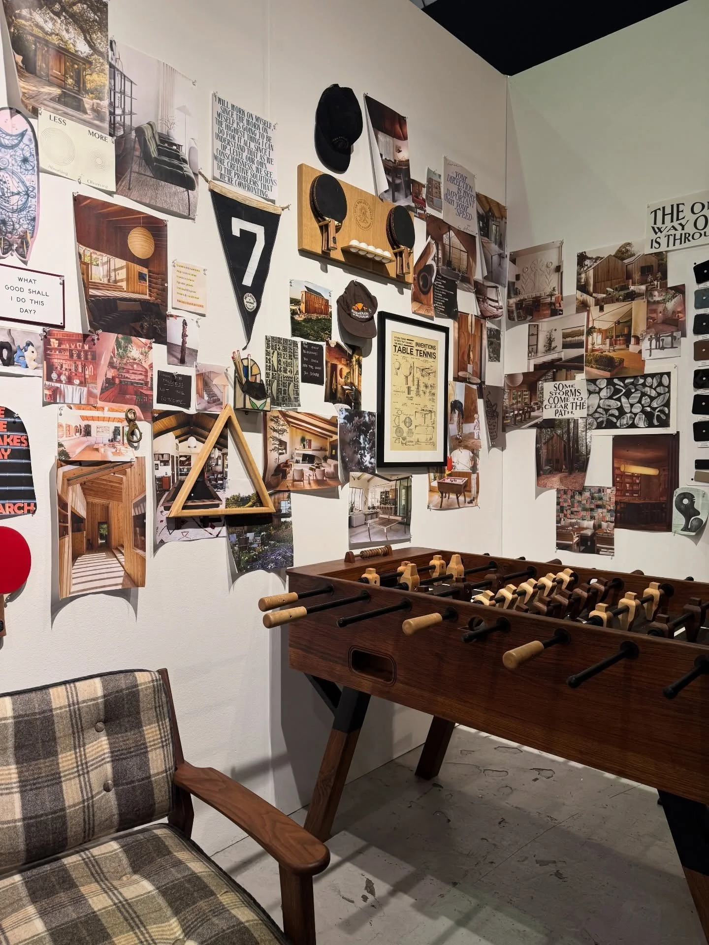 Studio display with a collage wall and a foosball table
