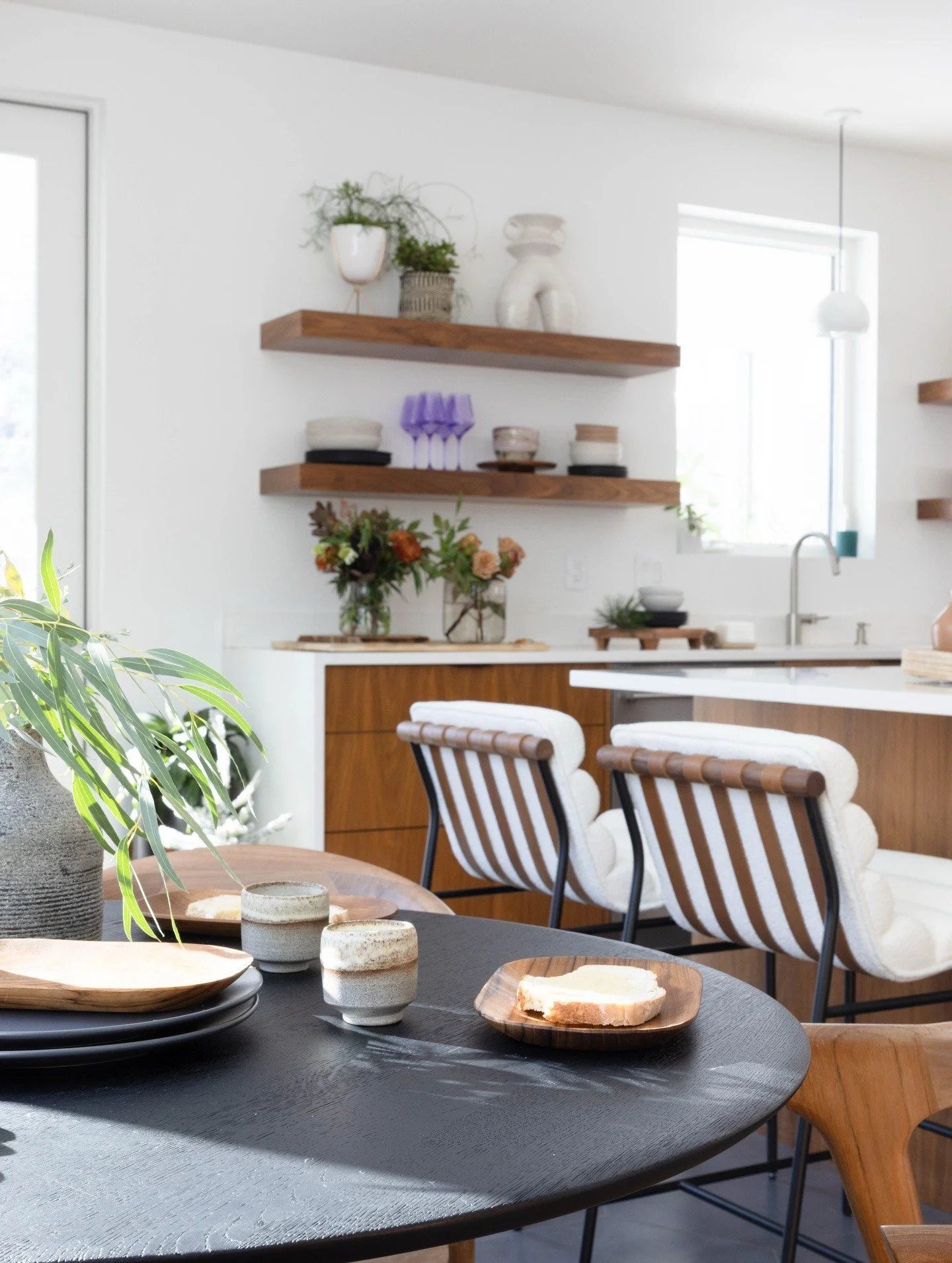 Curved wood stools beside a bright kitchen island