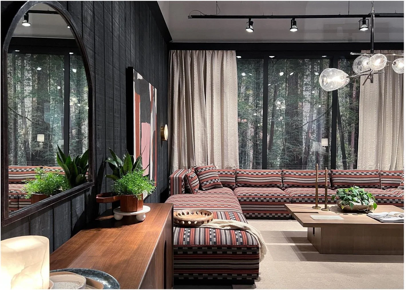 Patterned sectional framed by tall windows and dark wood walls