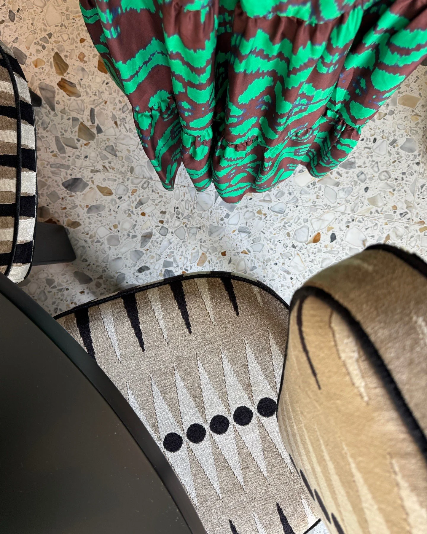 Green patterned fabric beside terrazzo and a woven basket