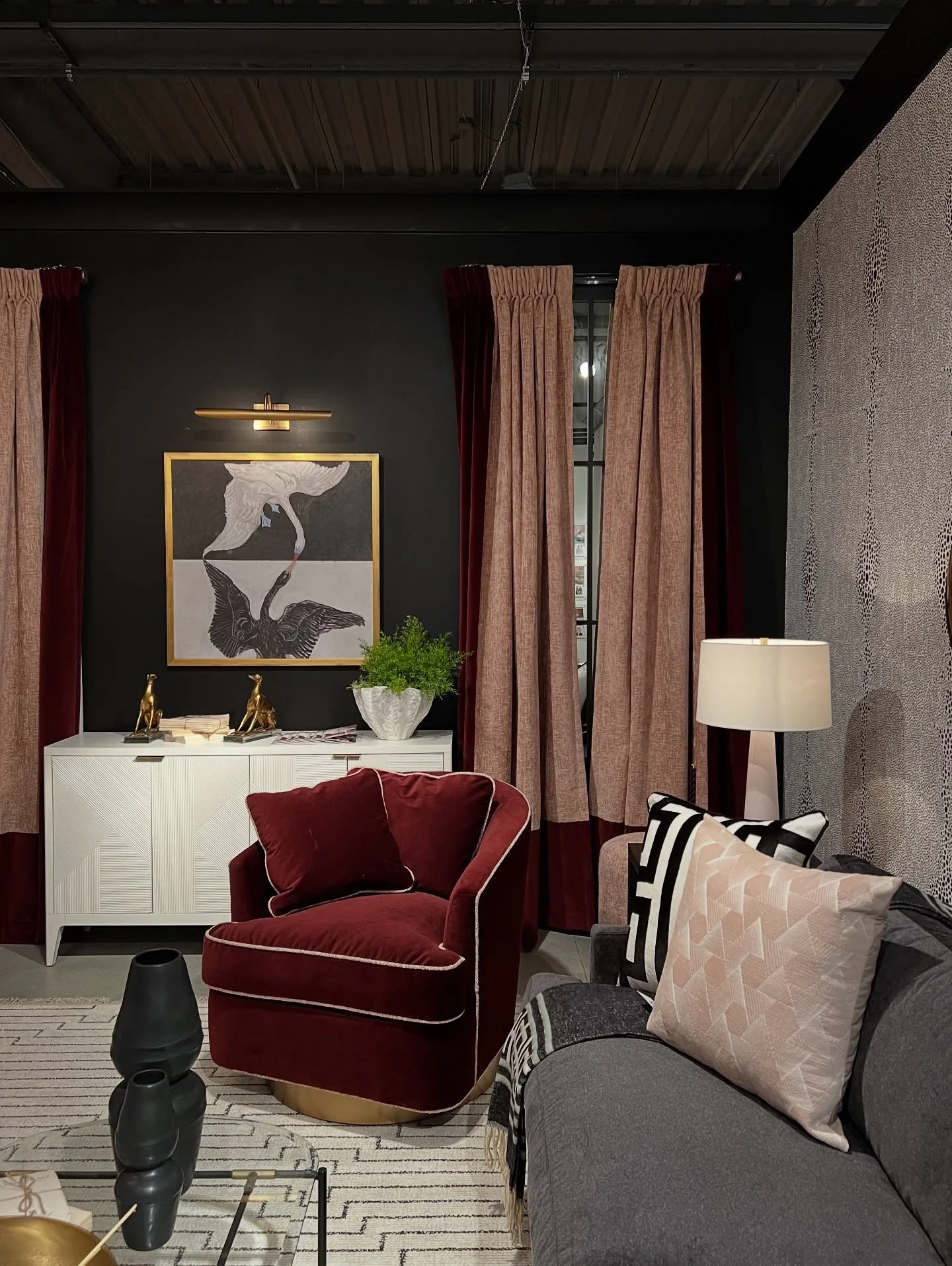Burgundy velvet chair beside pale cabinetry and sculptural art
