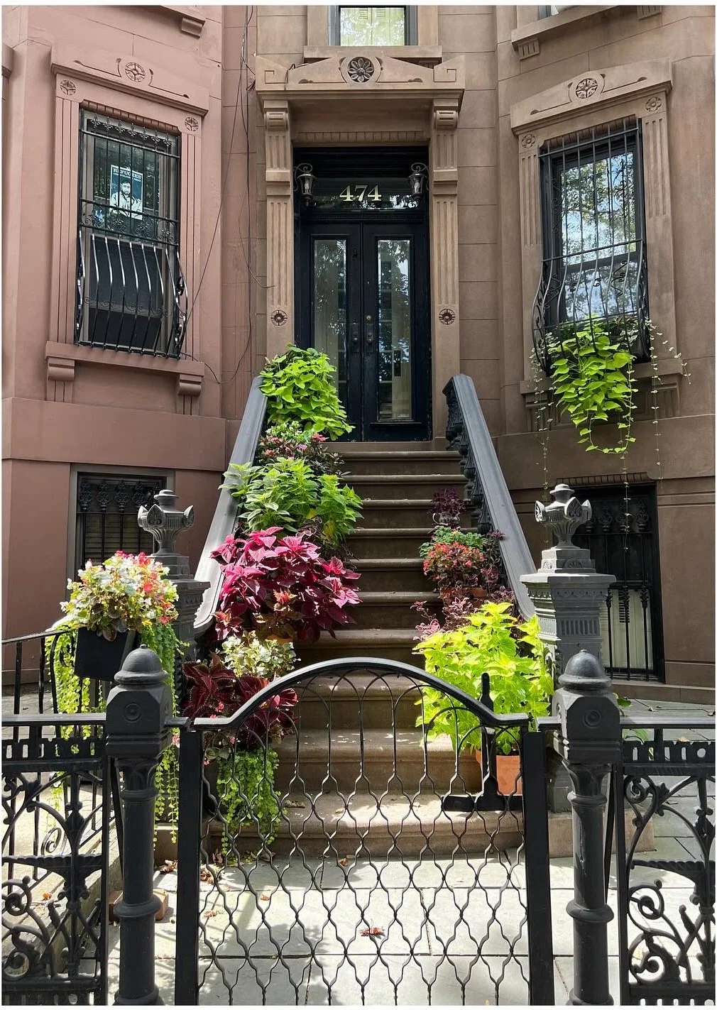 Ornate brownstone doorway with potted plants along the steps