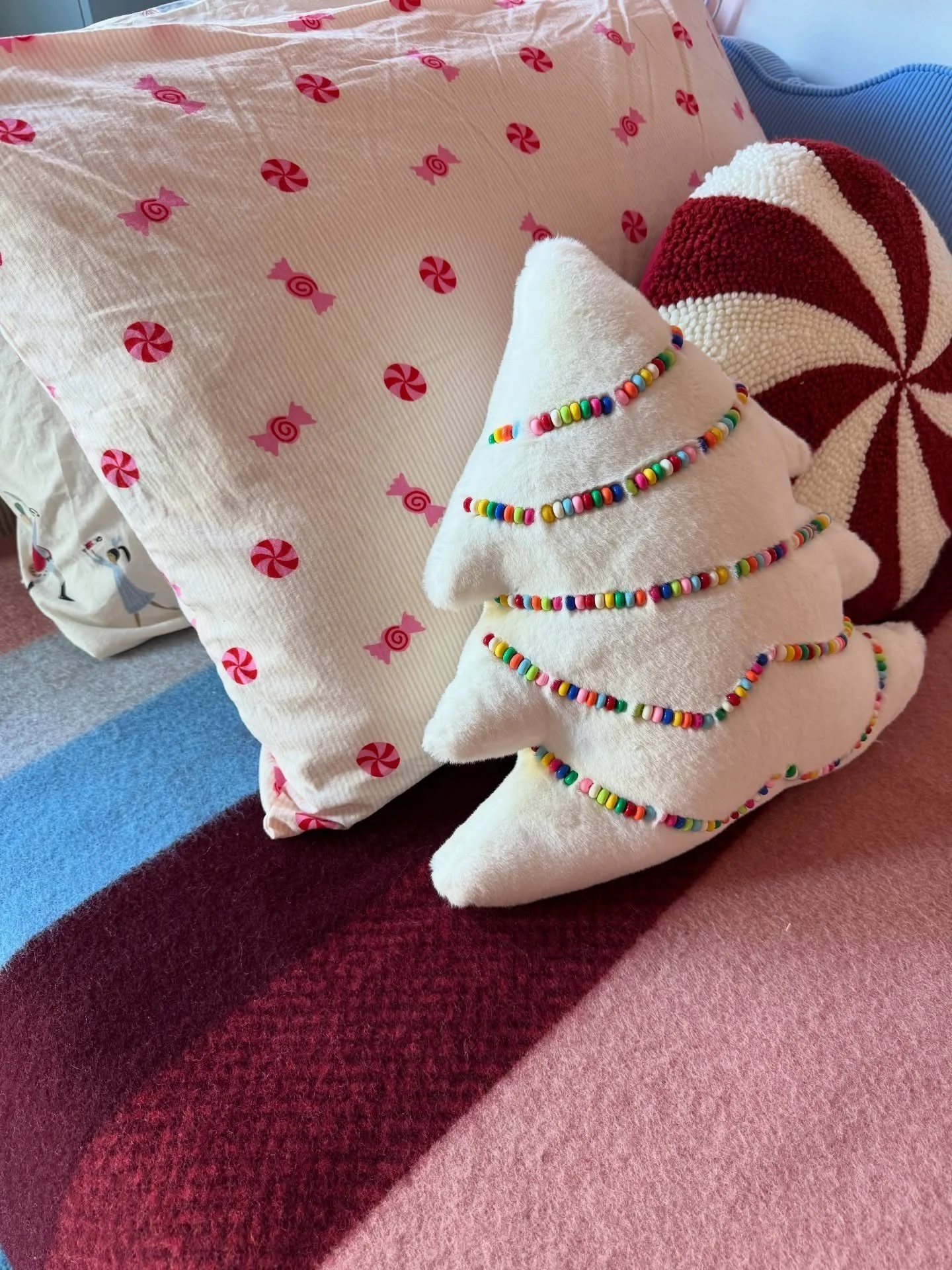 Festive embroidered cushions on a red and pink bed