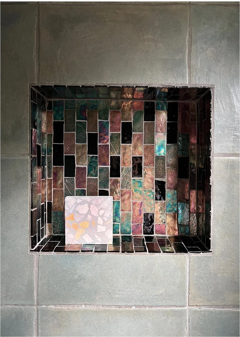Existing shower niche with narrow multicolored mosaic tiles