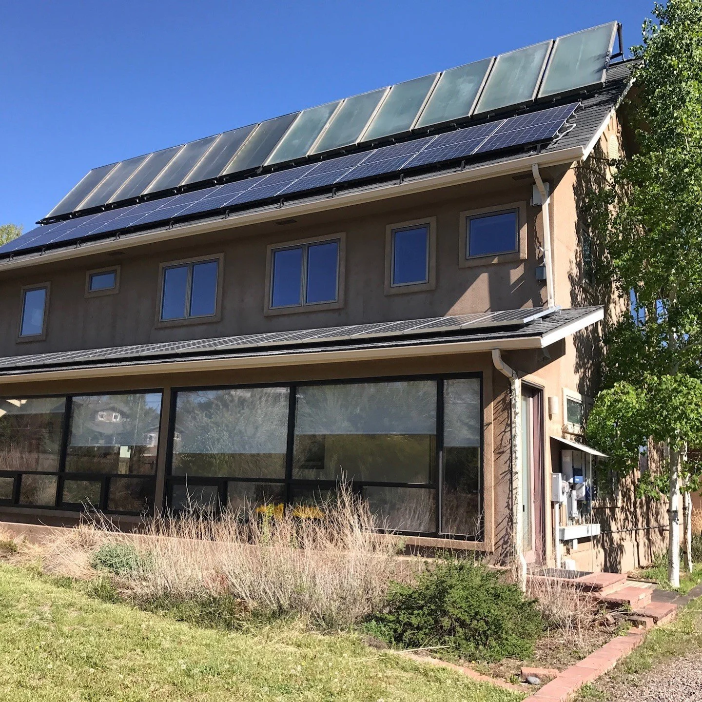 Original two-story home with a metal roof and enclosed porch