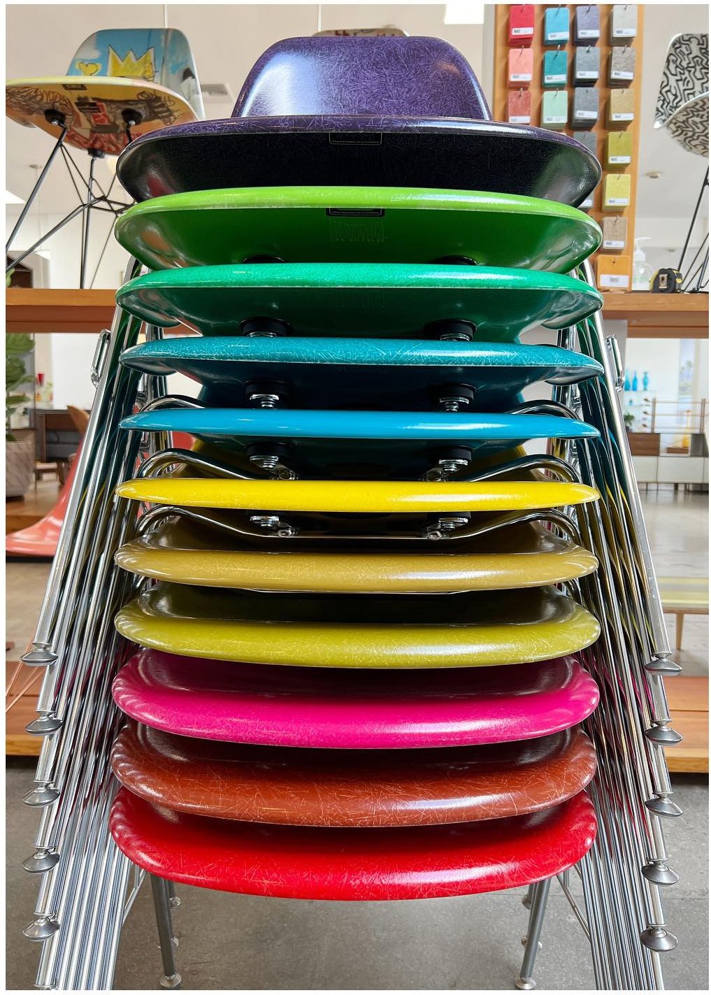 Stack of brightly colored fiberglass chairs on metal legs