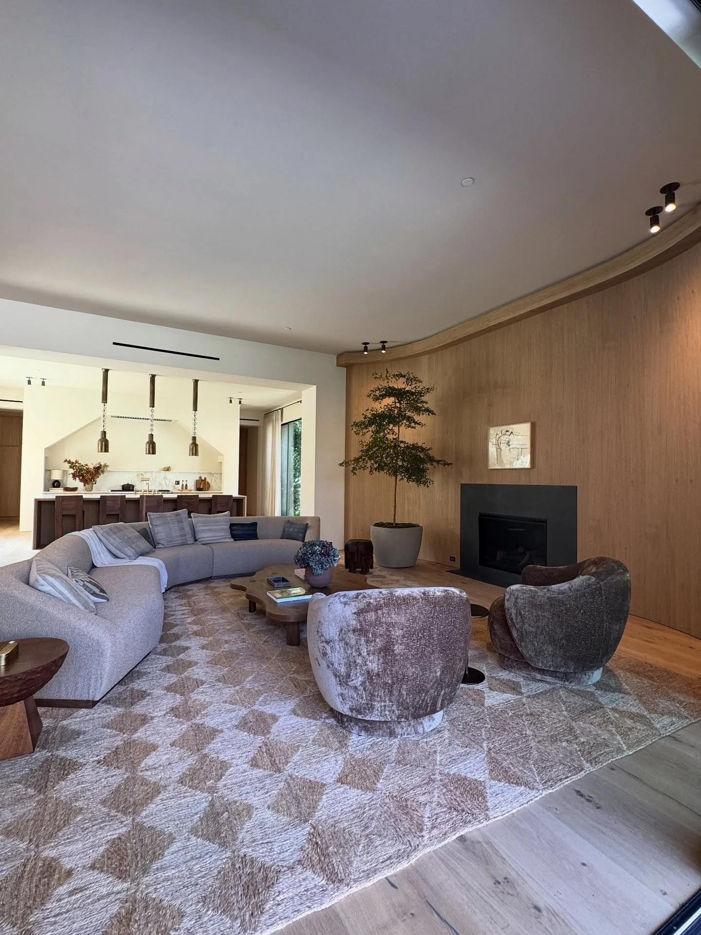 Curved living room with pale seating and sculptural stone tables