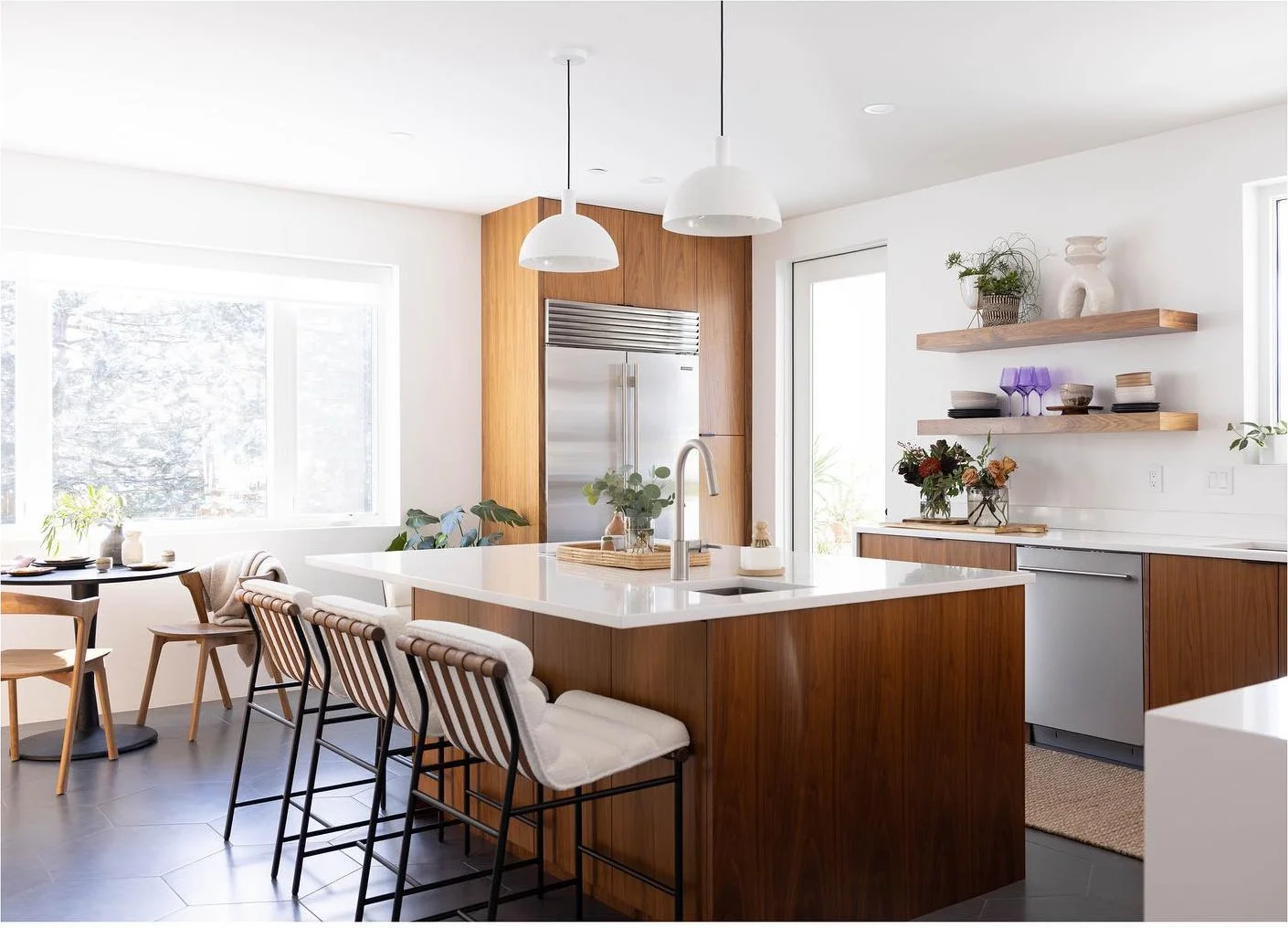 Light-filled wood kitchen with island seating and white pendant lamps