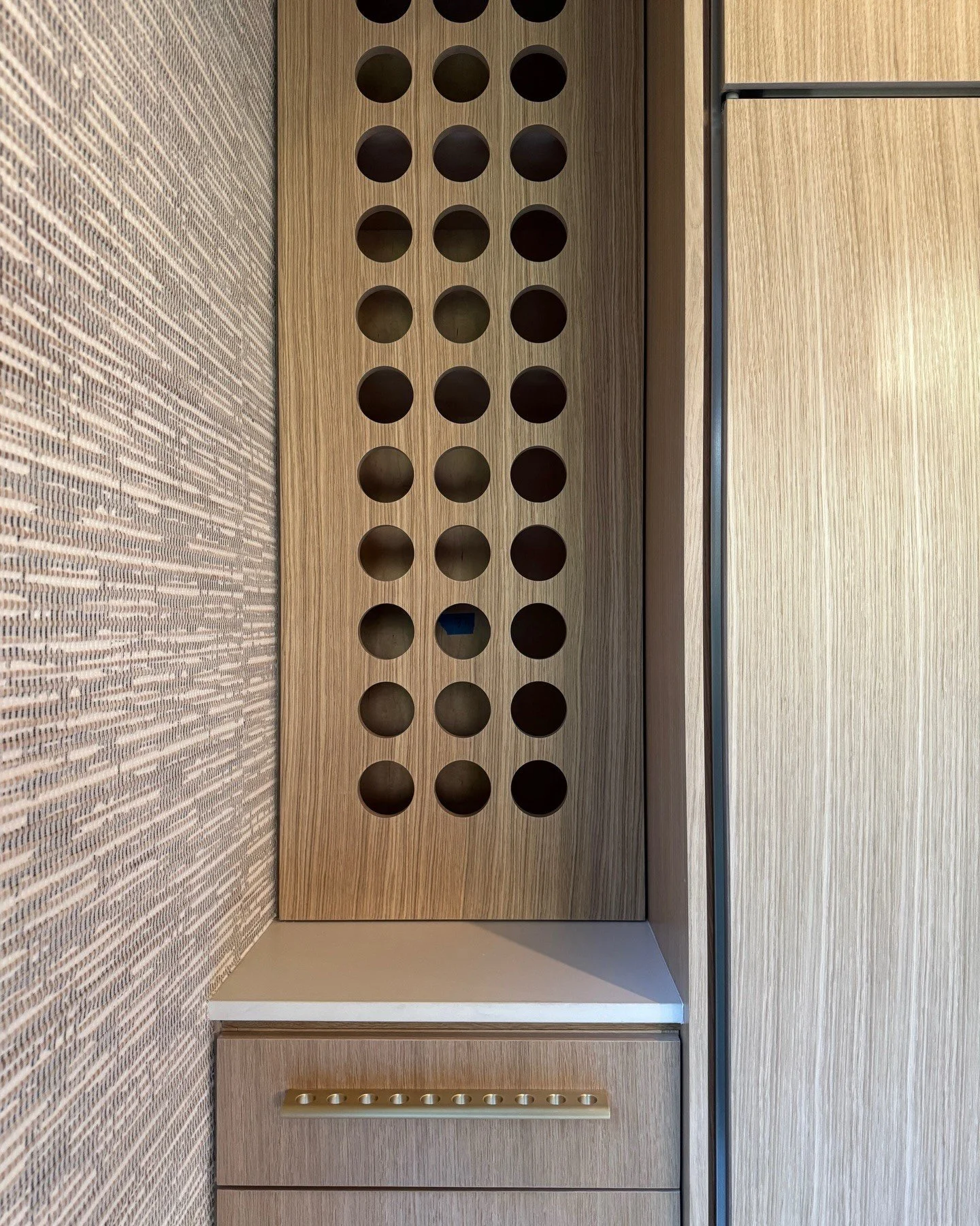 Built-in wood cabinet with circular ventilation holes and drawers