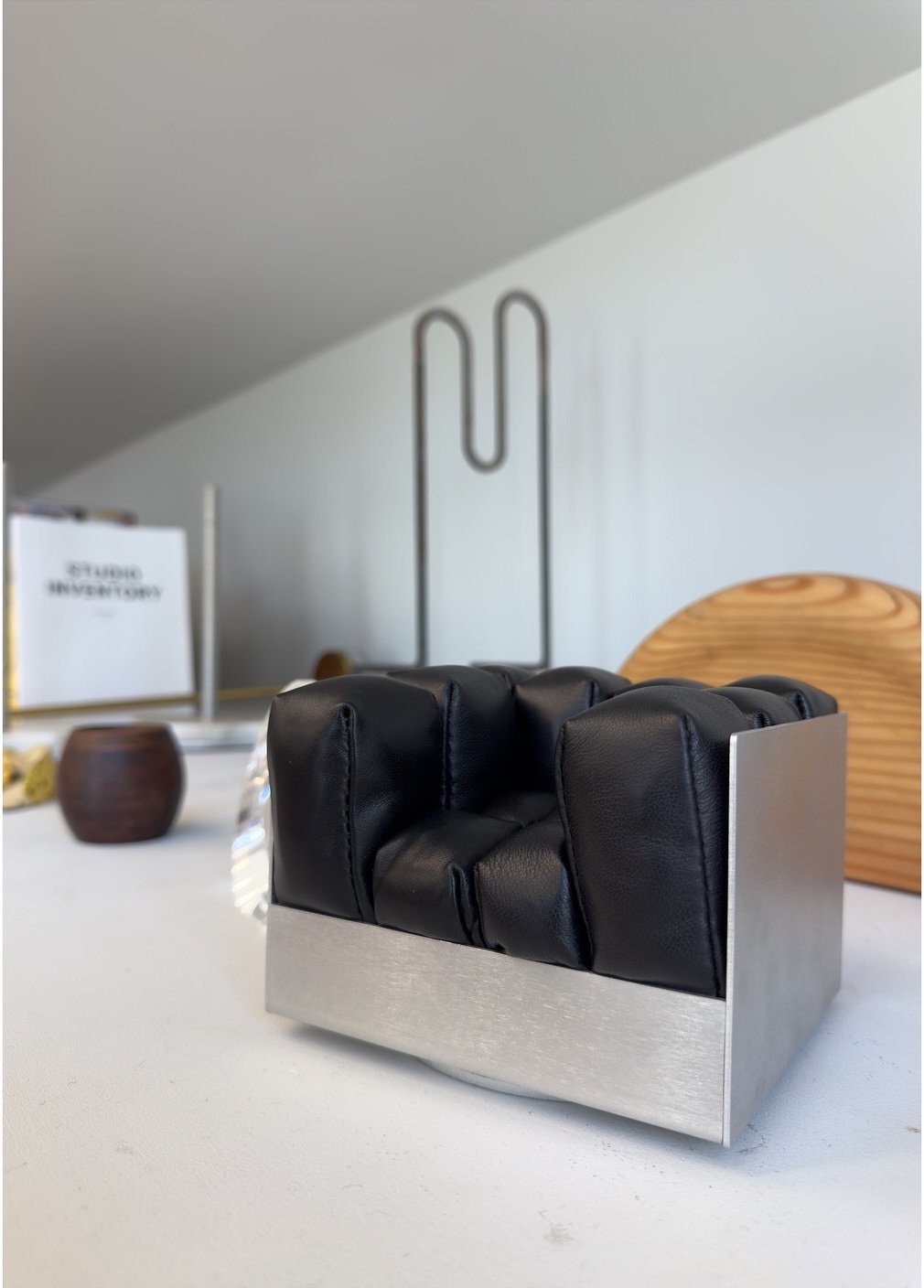 Black leather chair within a polished metal frame