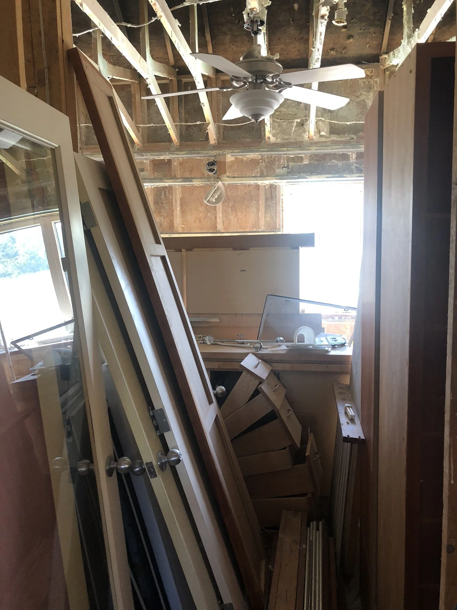 Construction materials stacked in an unfinished room with exposed ceiling framing.
