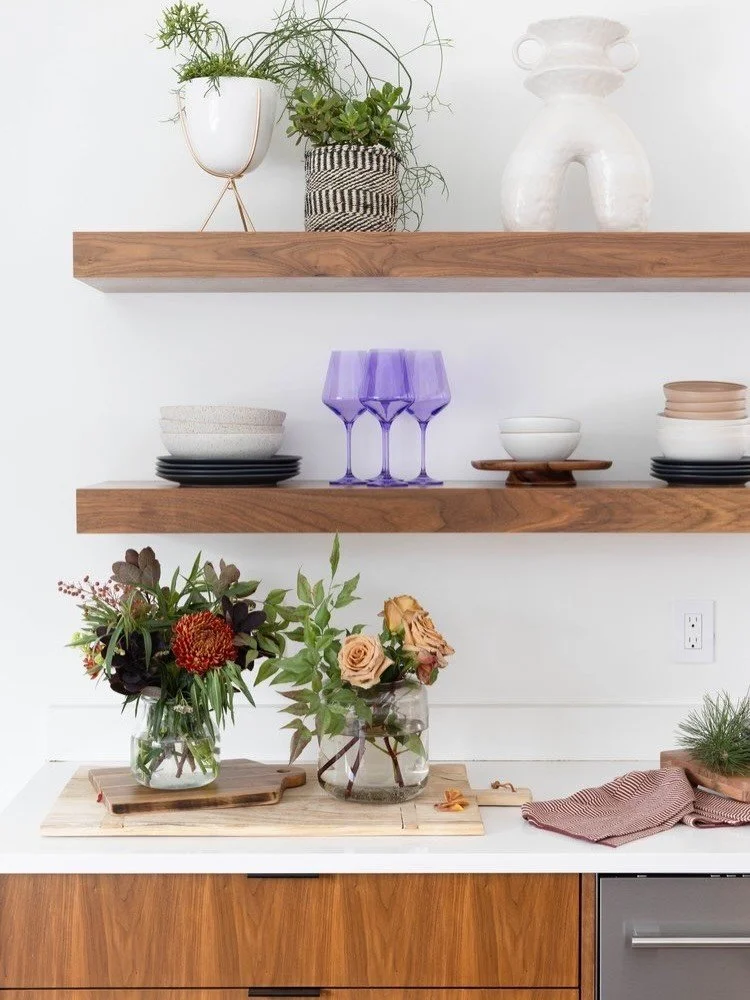 Wood kitchen shelves styled with plants and purple stemware
