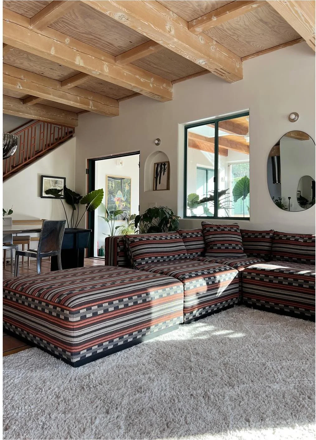 Patterned sectional and ottoman on a large pale textured rug
