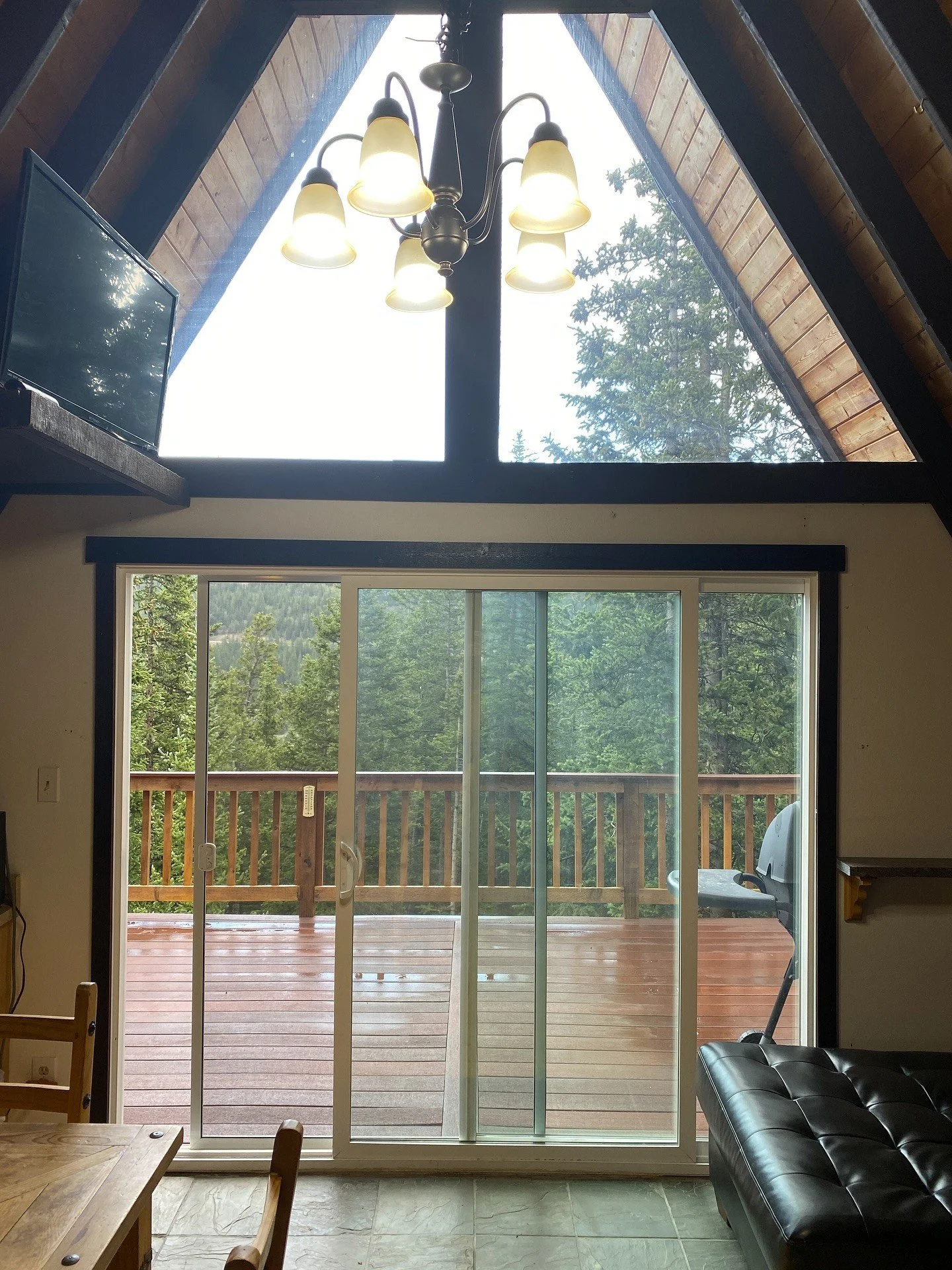 Original A-frame entry with tall triangular windows and dark beams