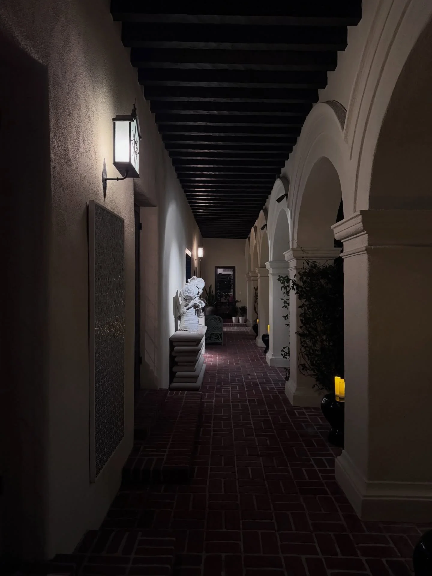 Arched colonnade with brick paving and exposed roof beams