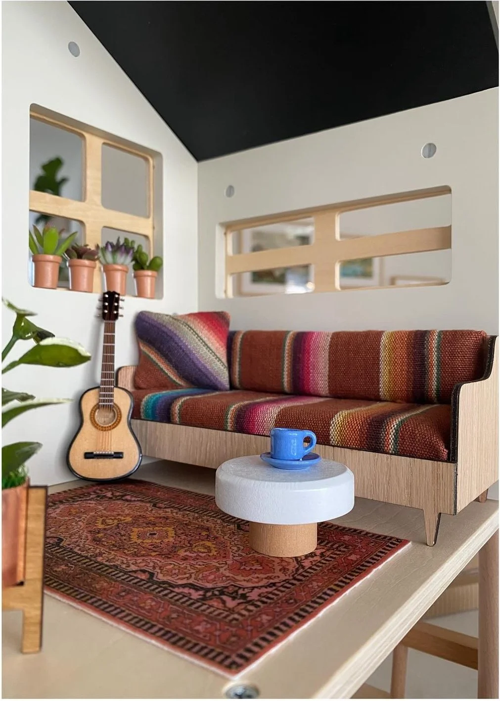 Dollhouse living room with custom striped sofa and a tiny guitar