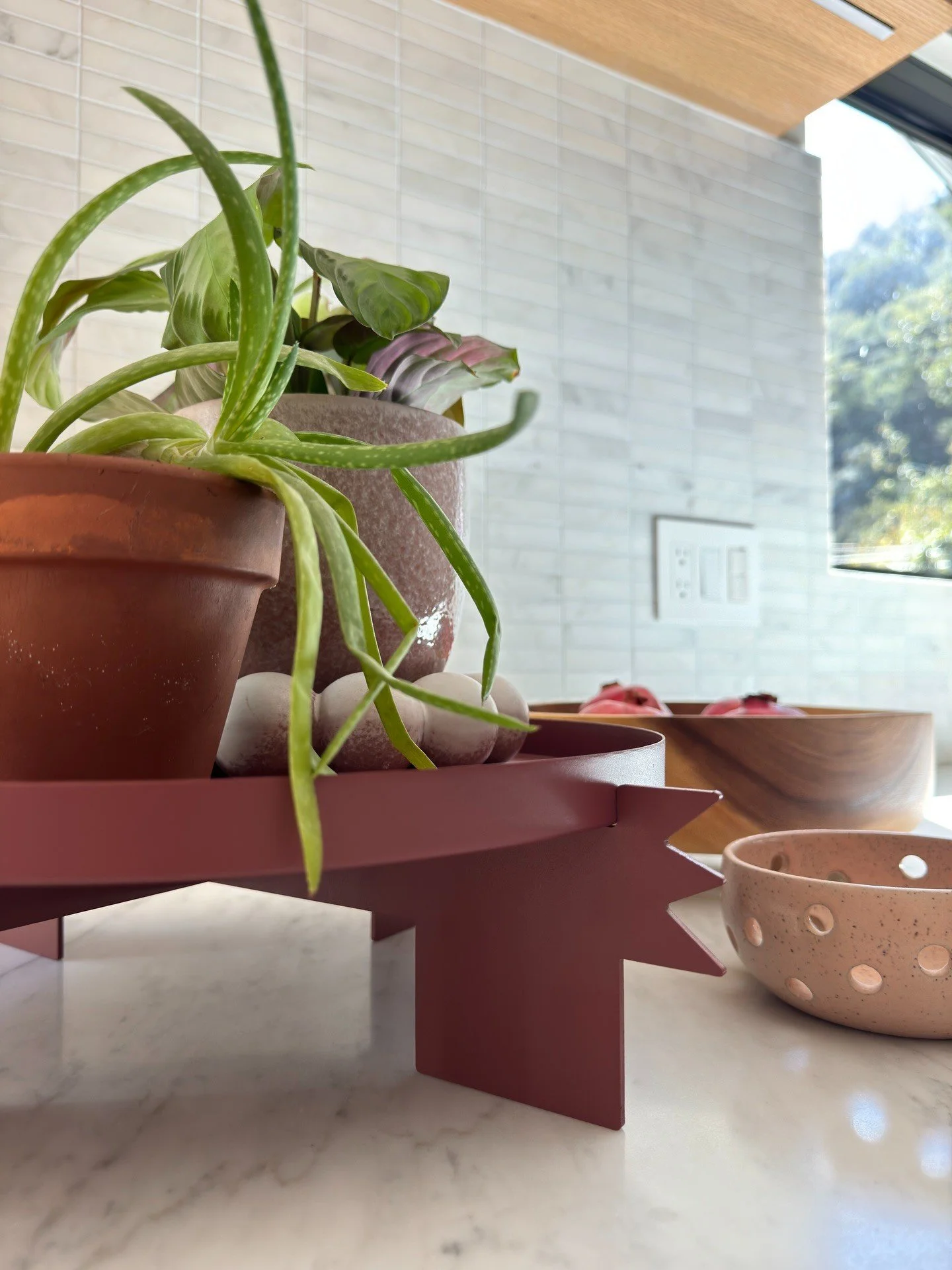 Terracotta pots and trailing plants on a red stool
