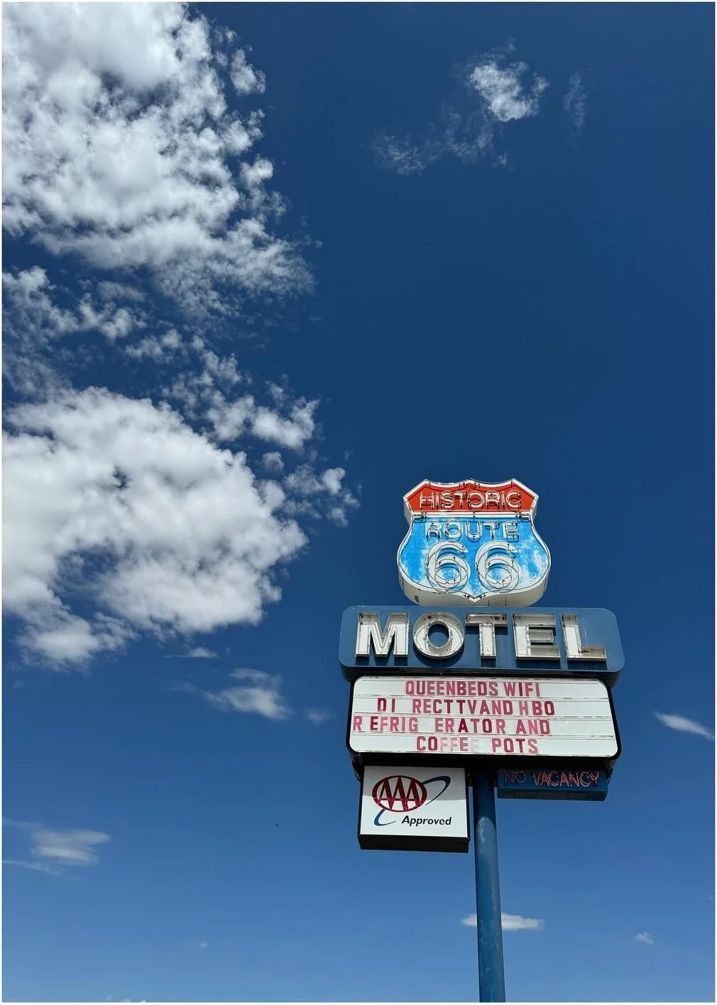 Vintage Route 66 motel sign against a deep blue sky