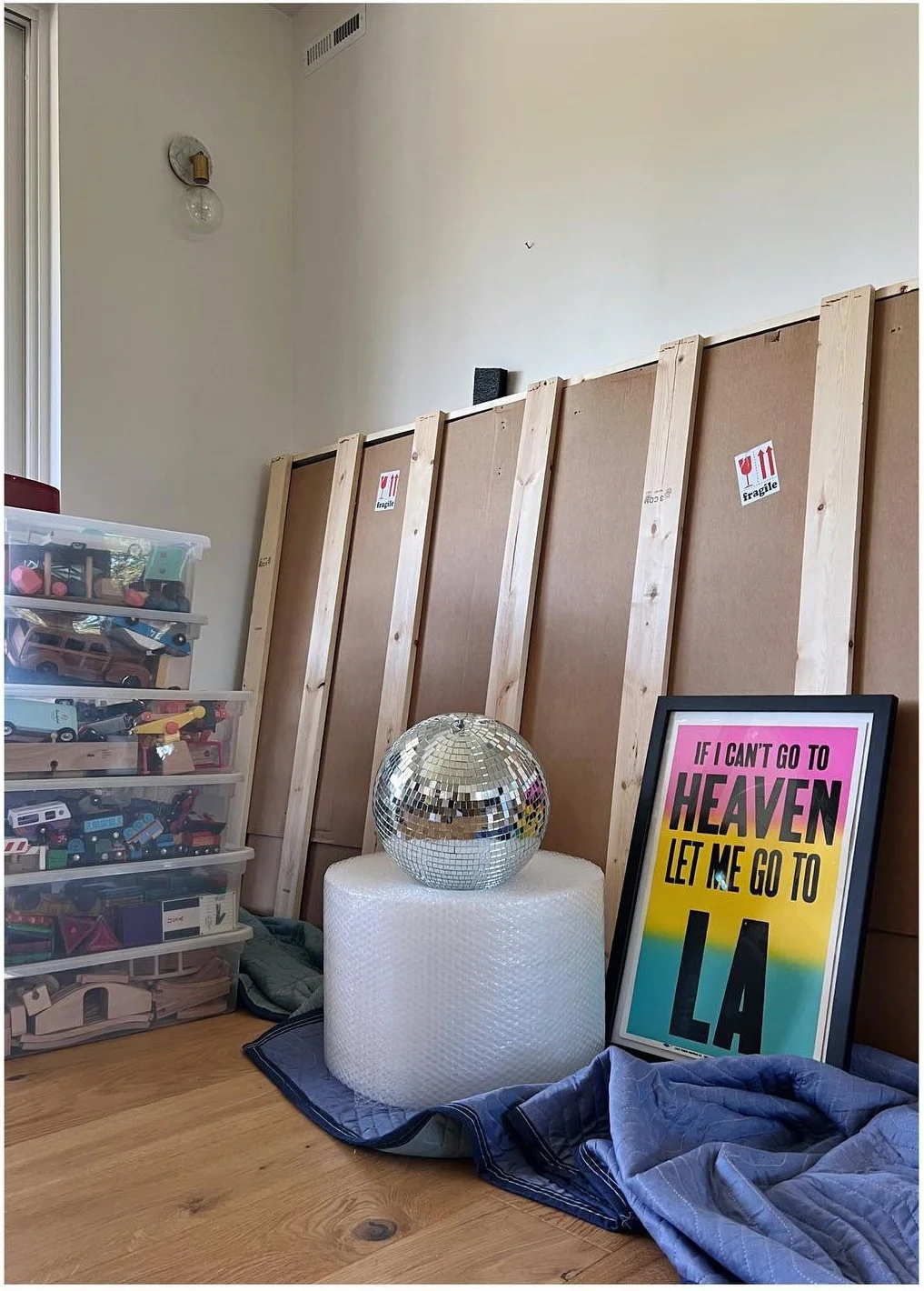 Colorful framed poster beside packed belongings and a silver globe.