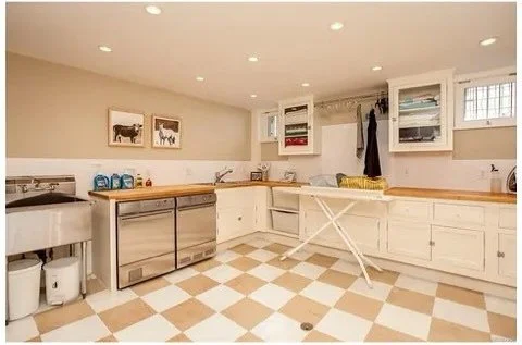 Original cream laundry room with checkerboard flooring and folding table