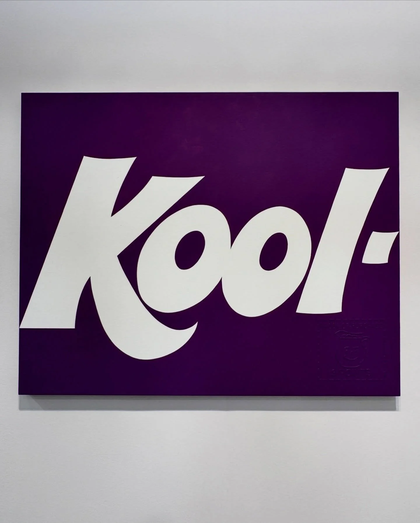 Purple text-based artwork displayed on a white gallery wall
