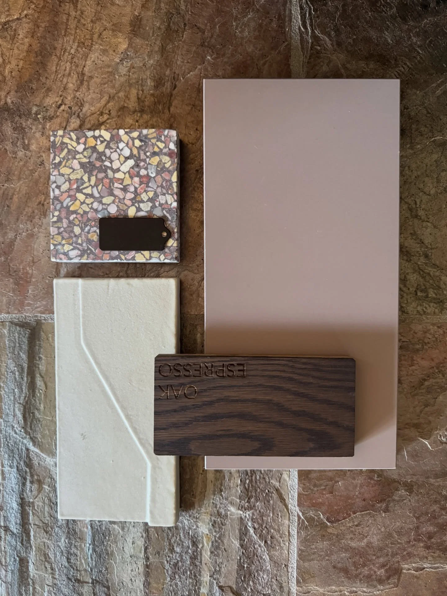 Taupe tile and dark wood samples on a warm stone floor