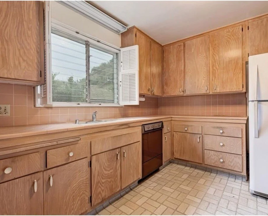 Original wood kitchen cupboards beneath a sliding window