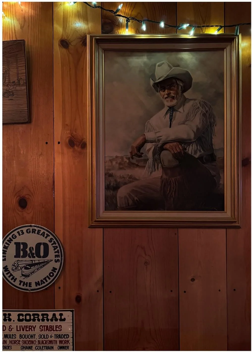 Framed Western portrait on a timber-paneled restaurant wall