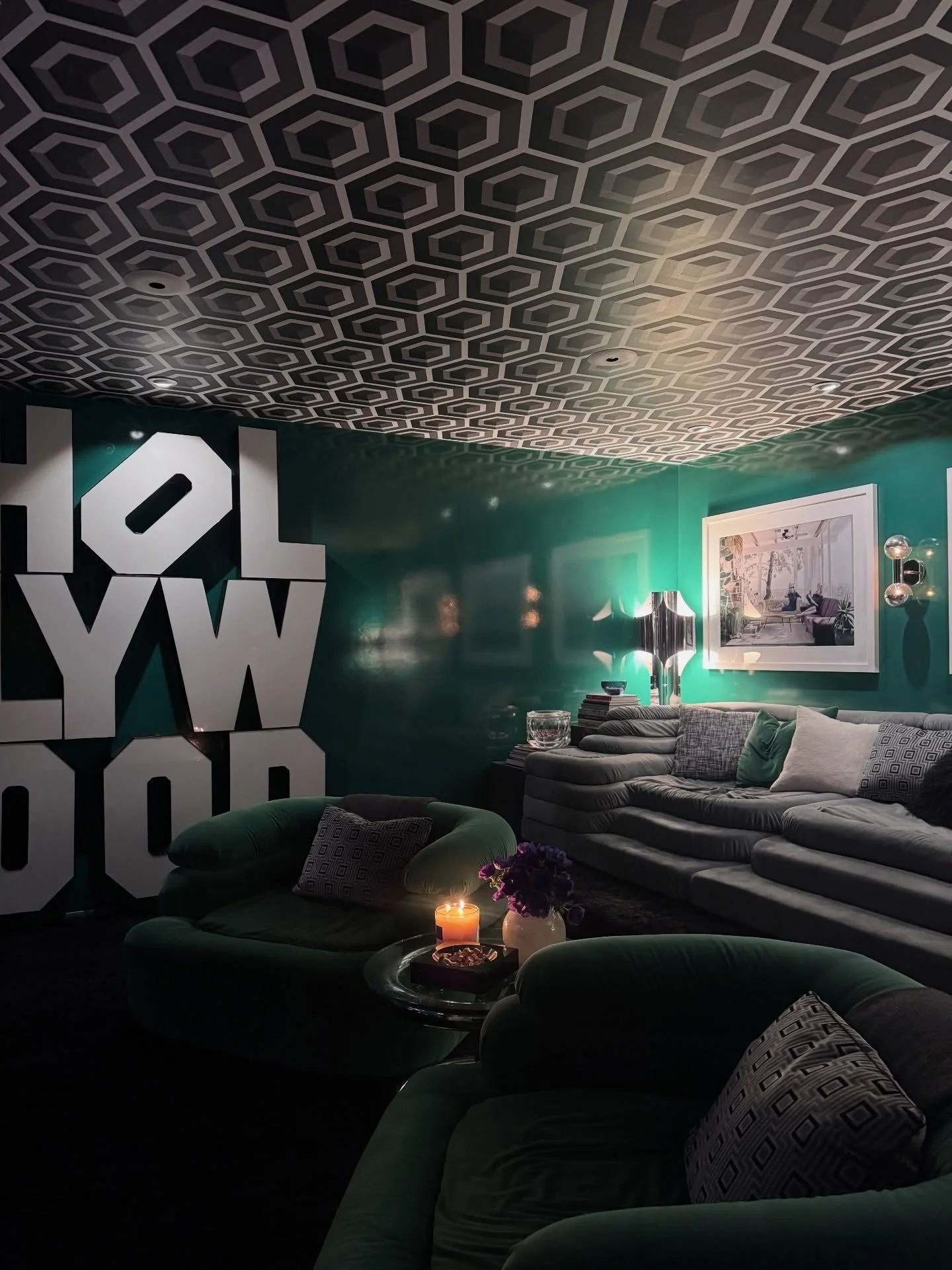 Emerald sitting room with geometric ceiling and monochrome artwork