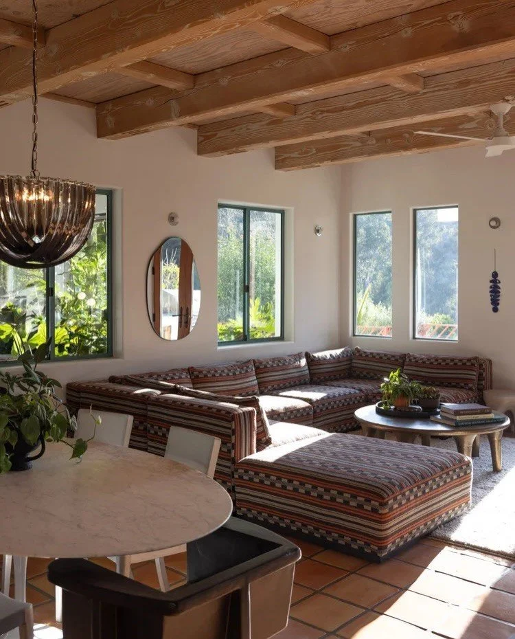 Sunlit sitting room with low patterned seating and garden views
