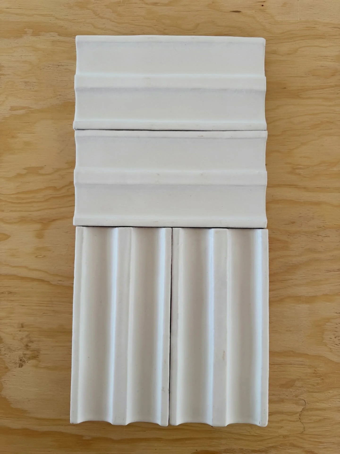 White fluted tile samples arranged in a vertical stack