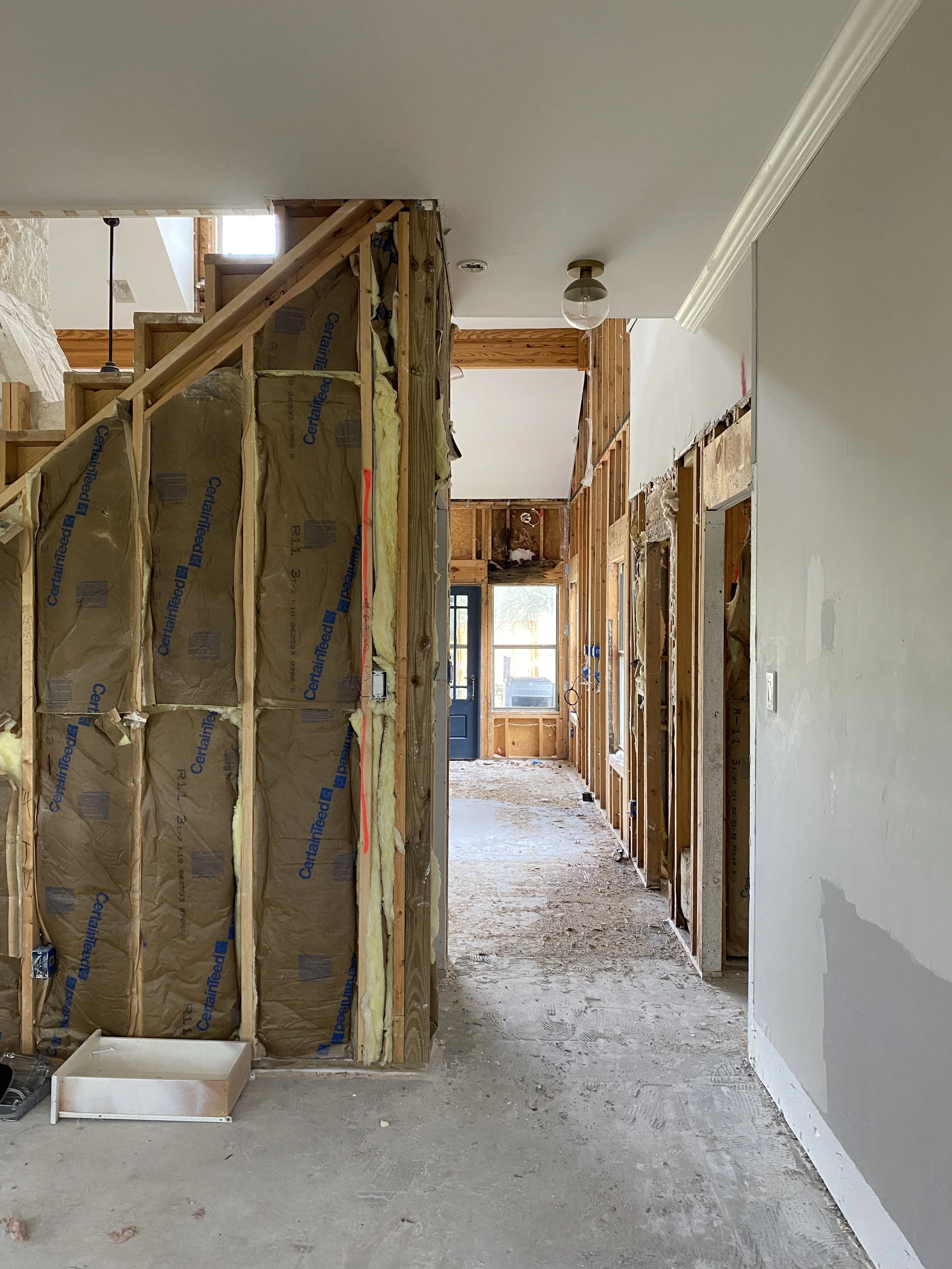 Hallway under renovation with exposed framing and insulation.