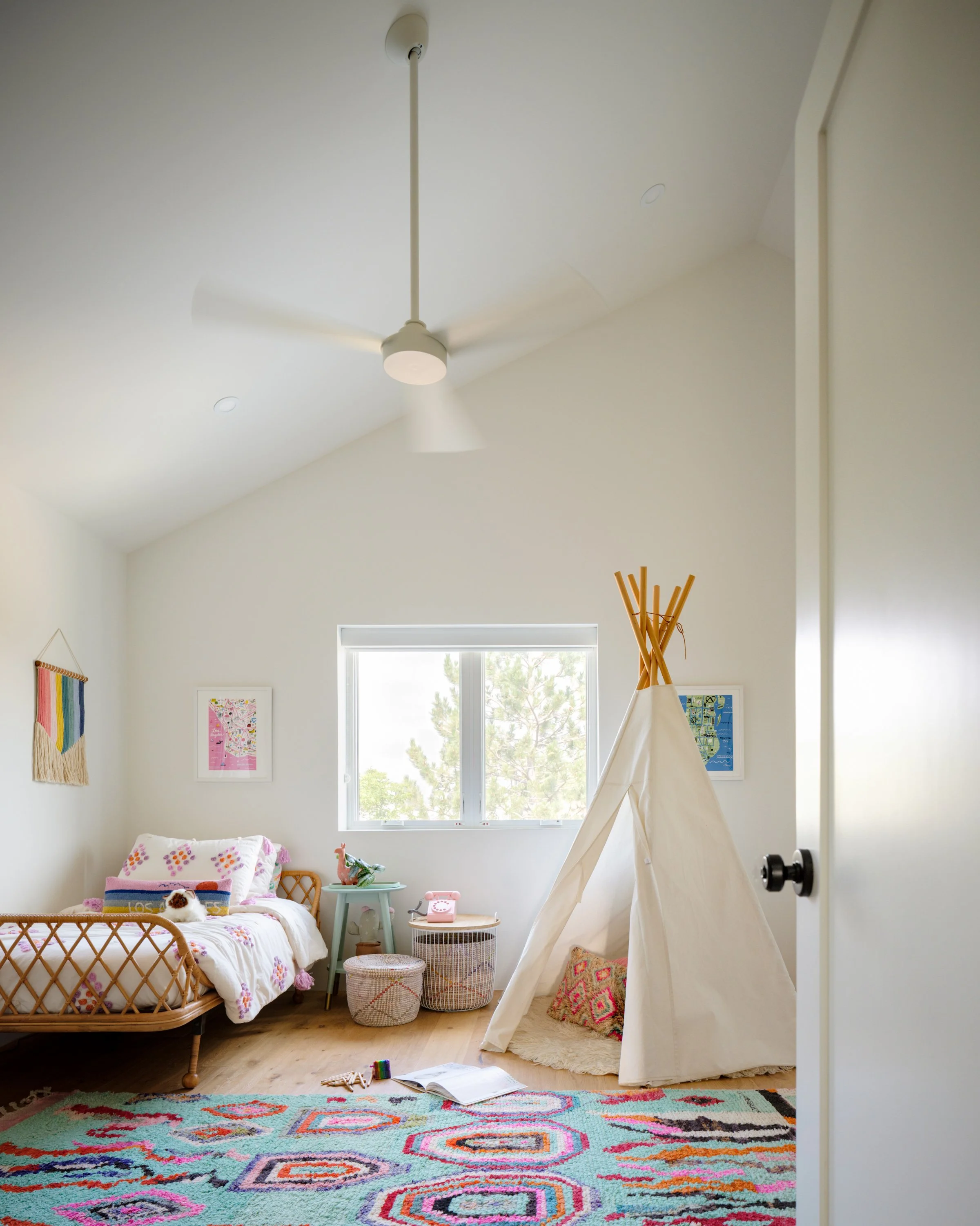 Child’s bedroom with a play tent, low bed, and colorful rug.