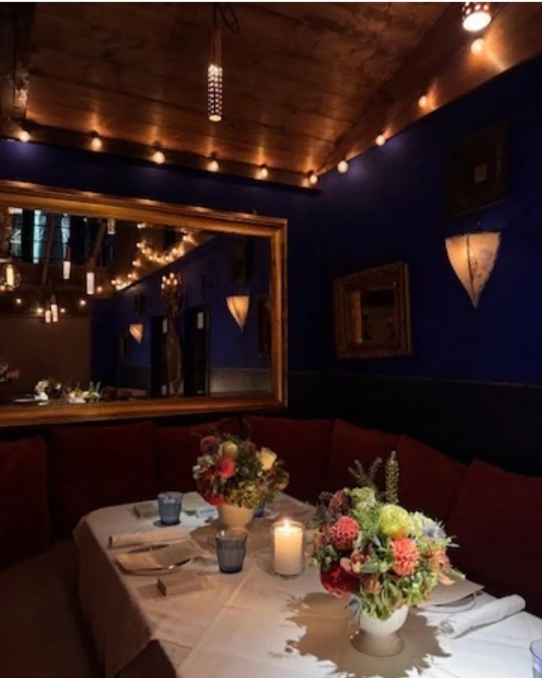 Moody restaurant dining room with blue walls and warm lamps