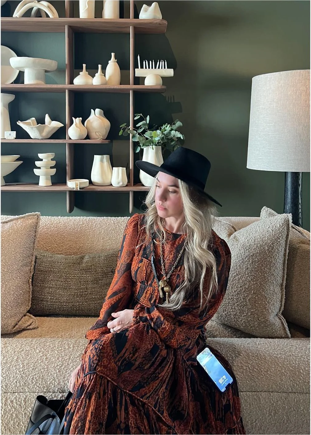 Designer reviewing a pale upholstered sofa in a ceramics-filled showroom